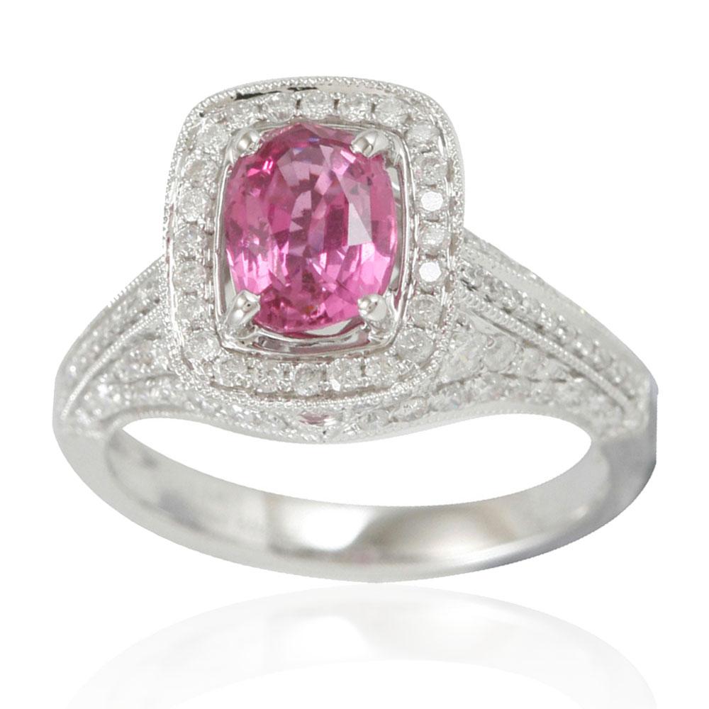 This Suzy Levian ring is an exclusive, limited edition pink sapphire and diamond ring. The vibrant pink of this ring's sapphire elongated cushion-cut center stone makes your skin seem to glow with health. The pink sapphire (1.47ct) is surrounded by