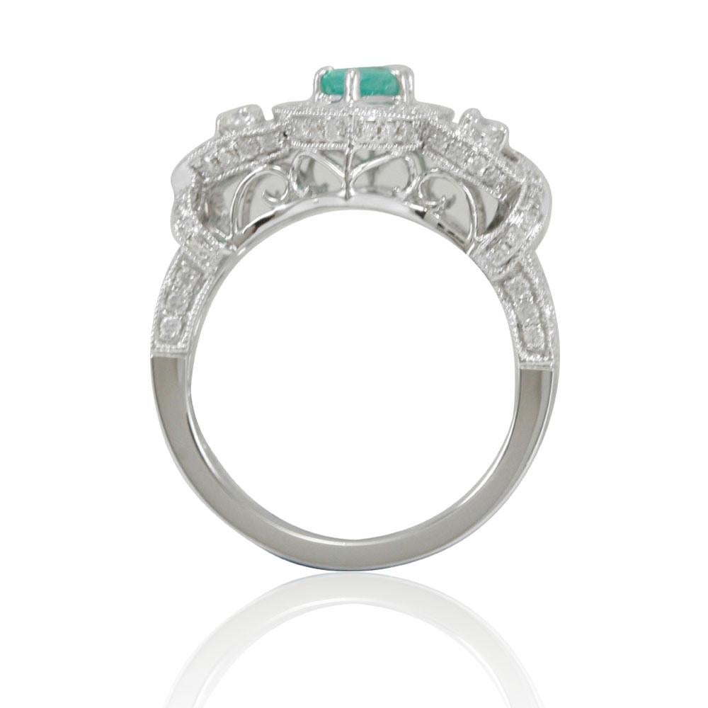 This spectacular ring from the Suzy Levian Limited Edition collection features a Colombian emerald gemstone (0.59ct) held in a 14K white gold prong setting. An array of 102 pave white diamonds (.67ct) with hand-carved French filigree work across the