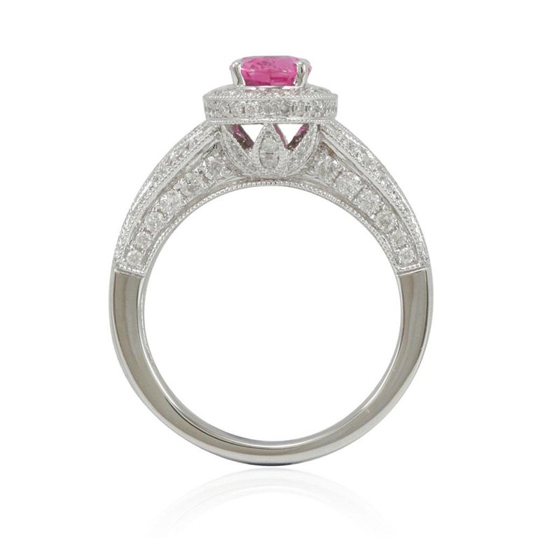 This spectacular cocktail cluster style ring from the Suzy Levian limited edition collection features a large ceylon pink sapphire center held in a 14K white gold prong setting. An array of 125 smaller white diamonds (.92TDW) with hand-carved French
