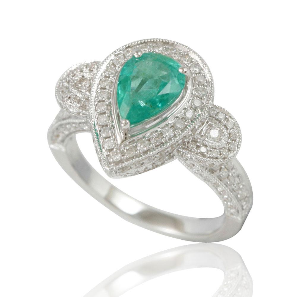 This spectacular ring from the Suzy Levian collection features a Colombian emerald gemstone held in a pear shaped 14K white gold prong setting. An array of 179 side white diamonds (.96ct) (H-I, I1-I2) with hand-carved French filigree work across the