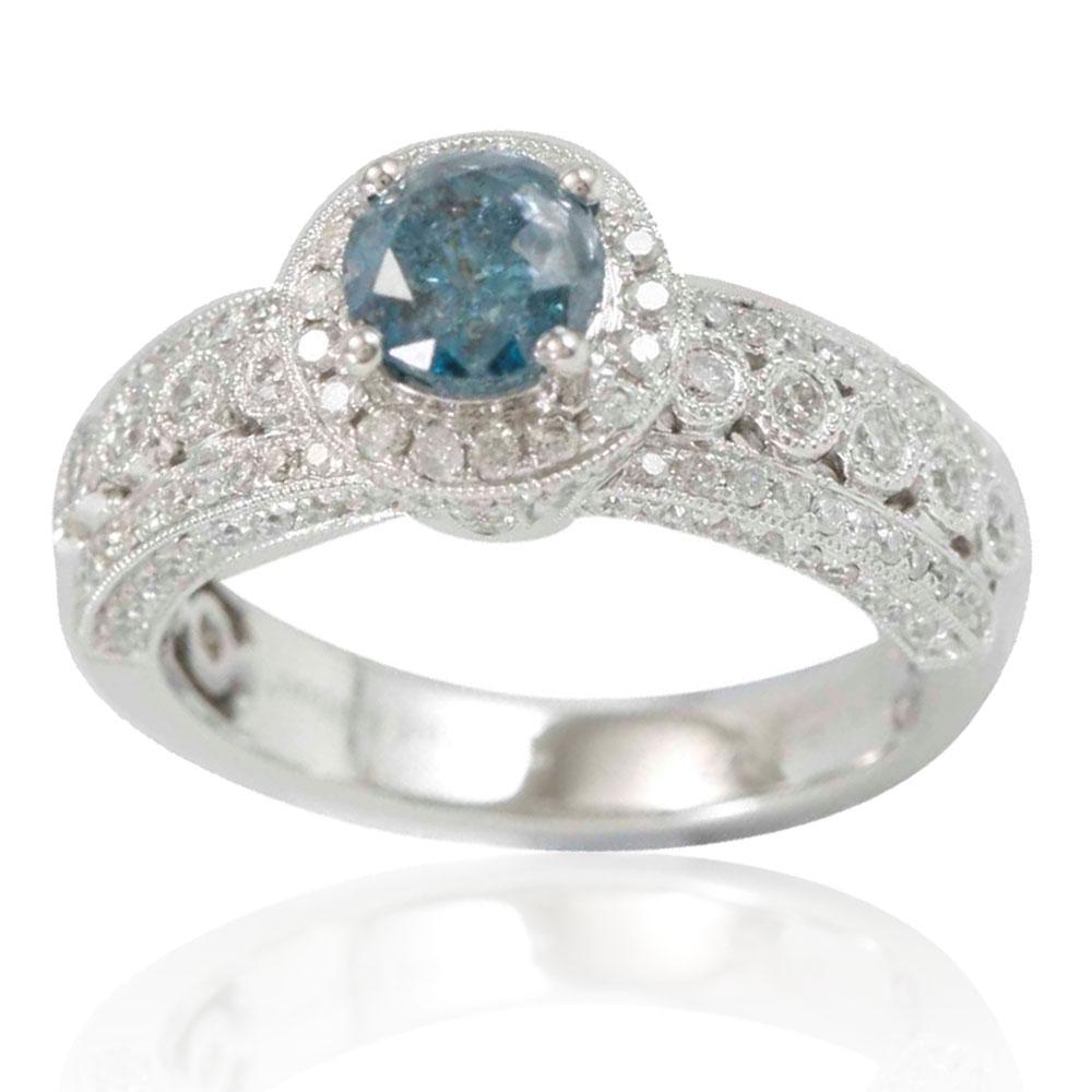 This stunning Suzy Levian ring features a gorgeous round-cut, rich blue diamond (1.07ct) center stone with an array of white diamond (.77cttw) accents, handset in a 14k white gold setting. French filigree hand-work carves impeccable detail and