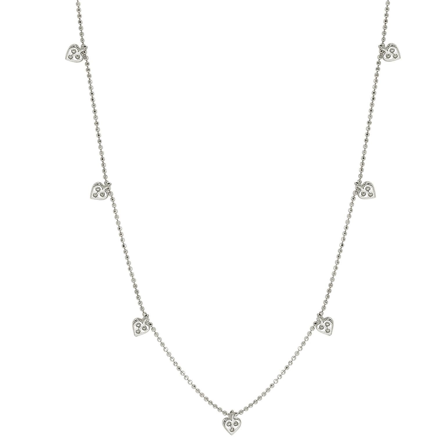 This unique Suzy Levian diamond station heart necklace displays round-cut diamonds on 14 karat white gold setting. This gorgeous necklace contains 21 white round cut diamonds totaling .26cttw. The necklace has 7 hearts, each heart contains 3 diamond