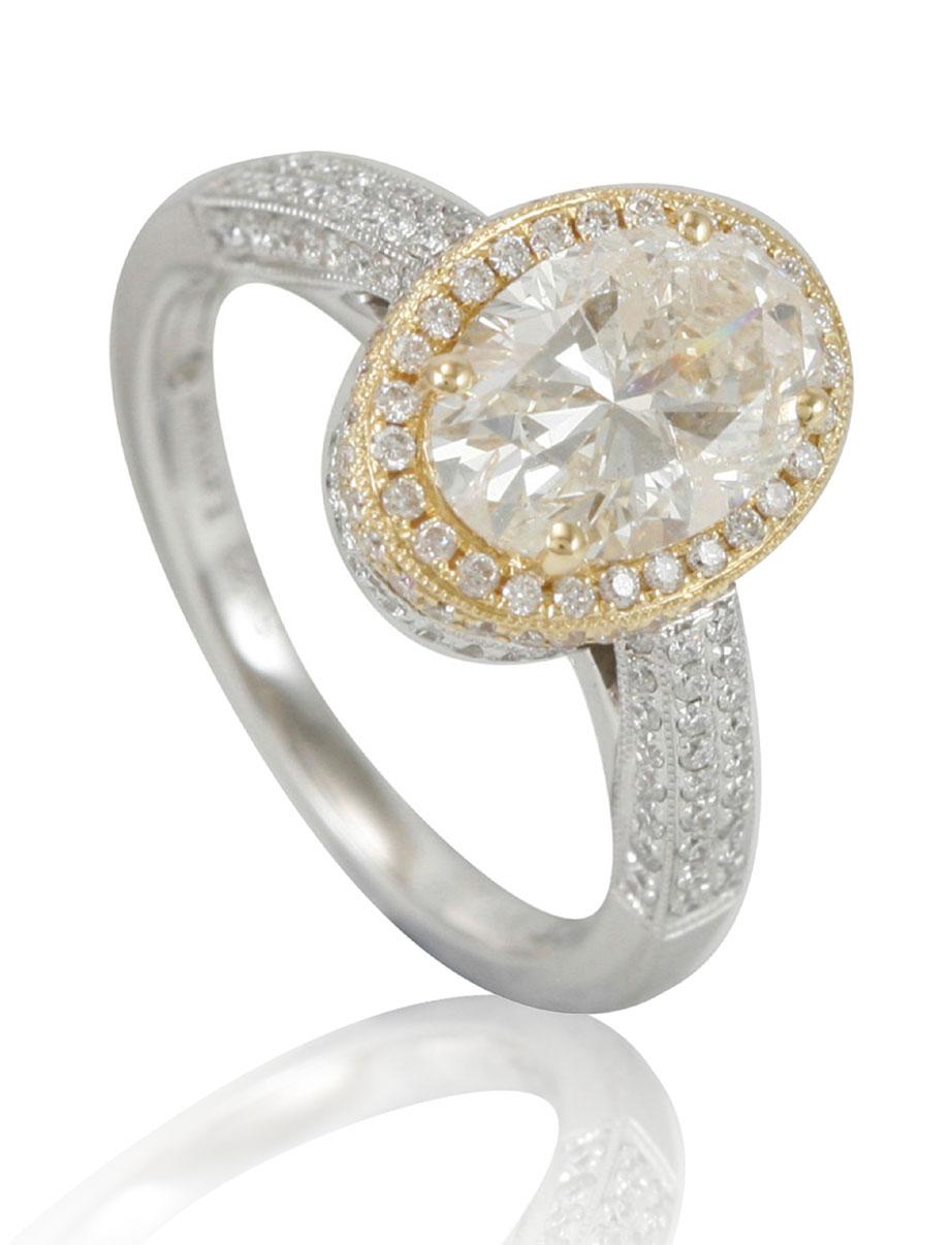 This spectacular ring from the Suzy Levian collection features an yellowish-white diamond center stone (2.08cttw), oval shaped, with an an array of white diamonds accents (.64cttw), beautifully crafted in 18k two-tone white and yellow gold. The