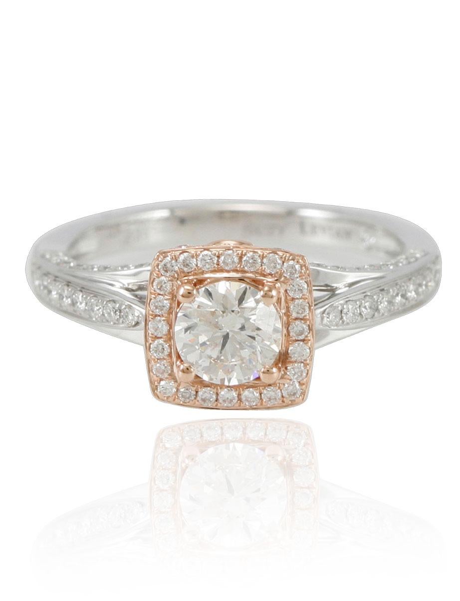 Un magnifique diamant de taille ronde dans un halo en or rose repose au sommet d'un anneau en or blanc, soutenu par de nombreux diamants latéraux dans une monture pavée. Une finition hautement polie complète ce look d'une beauté exquise.

Pierre