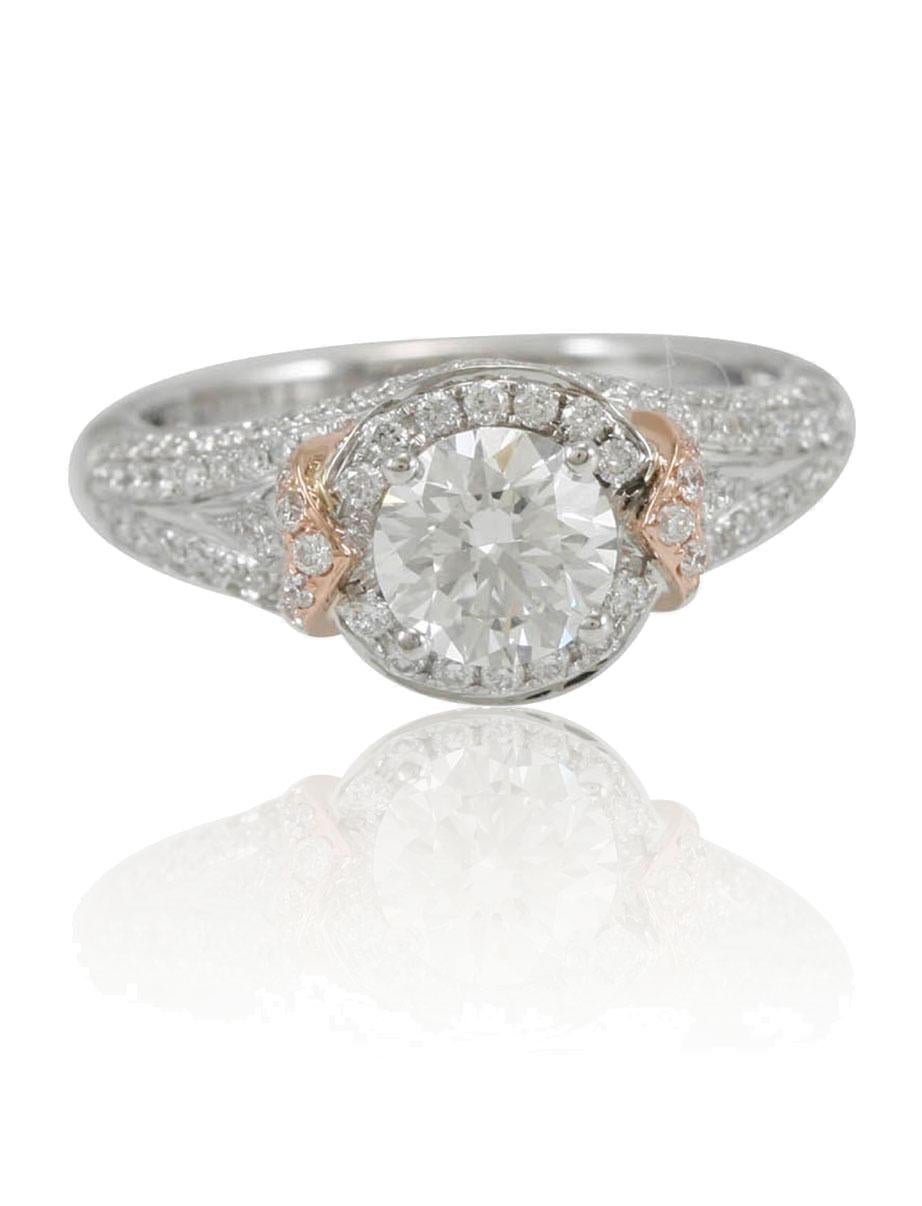 This spectacular ring from the Suzy Levian bridal collection features 18k two-tone white and rose gold. An array of pave white diamonds (1.02cttw) accent the band as a round-cut center stone (.68ct) is highlighted in the center. The brilliance of