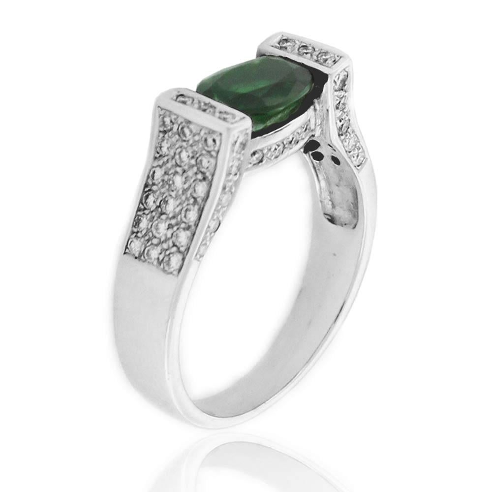 This spectacular ring from the Suzy Levian collection features 18k white gold. An array of white diamonds (.40cttw) accent the perfect oval-cut, green tourmaline gemstone center (1.02ct). The brilliance of these stones and the luster of the