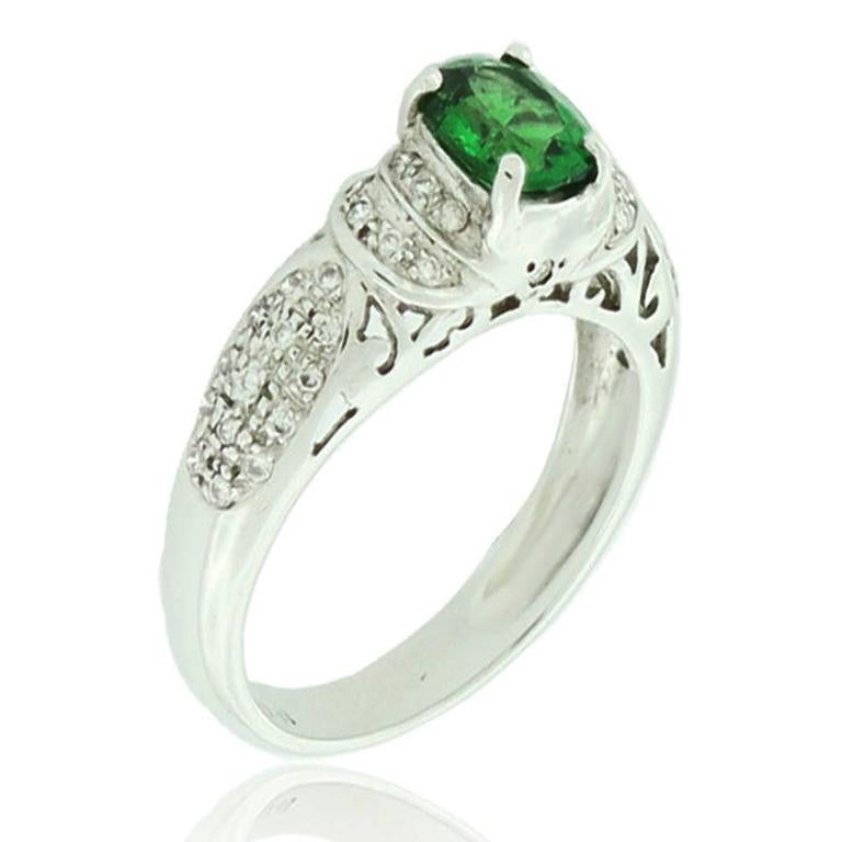 This spectacular ring from the Suzy Levian Limited Edition collection features 18k white gold. An array of pave, round-cut white diamonds (.86cttw) accent the perfect oval-cut, green tsavorite gemstone center (1.15ct). The brilliance of these gems