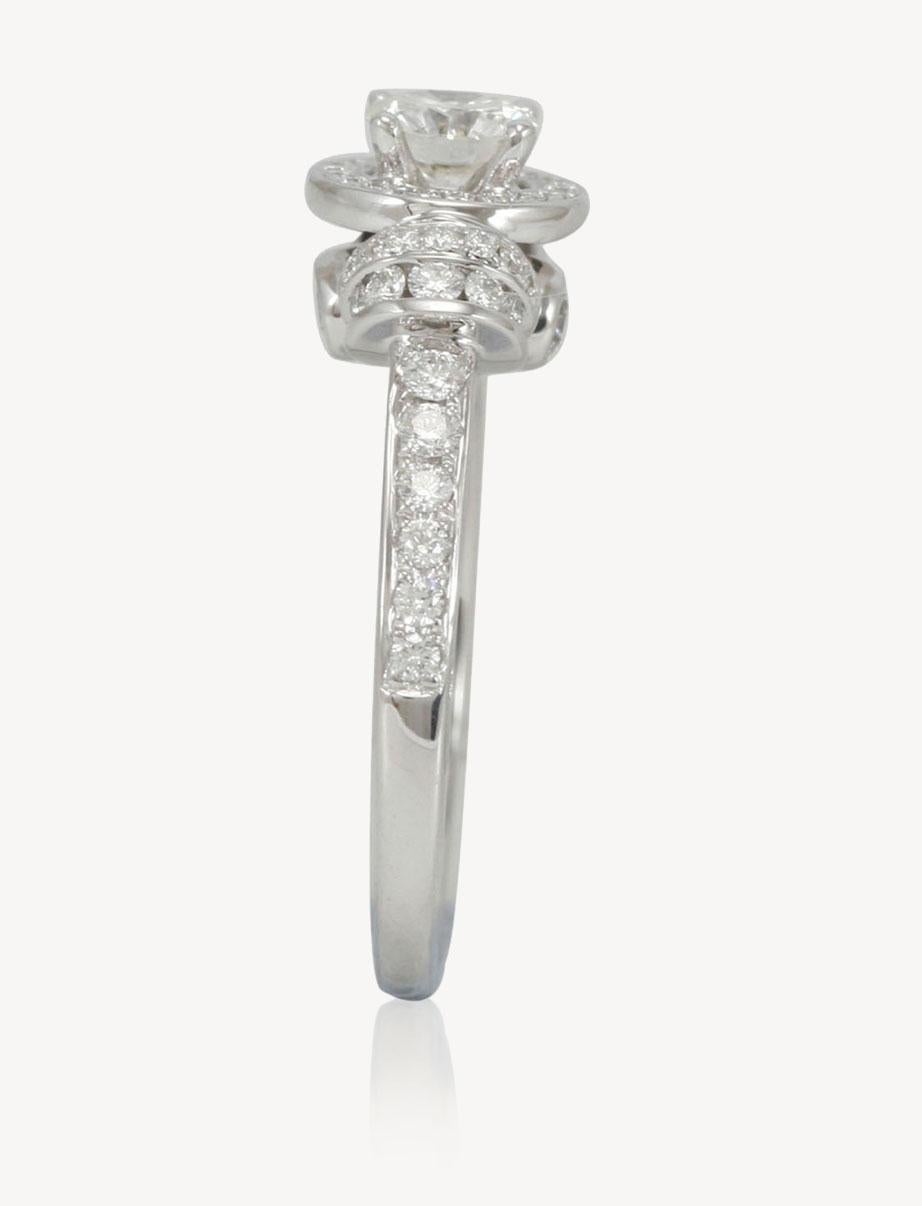 Dieser auffallend schöne Verlobungsring von Suzy Levian ist elegant aus 18 Karat Weißgold gefertigt und mit einem GIA-zertifizierten runden Brillanten in der Mitte besetzt (0,55ct). In einer Vintage-Halo-Fassung ist dieser Diamant in der Mitte von