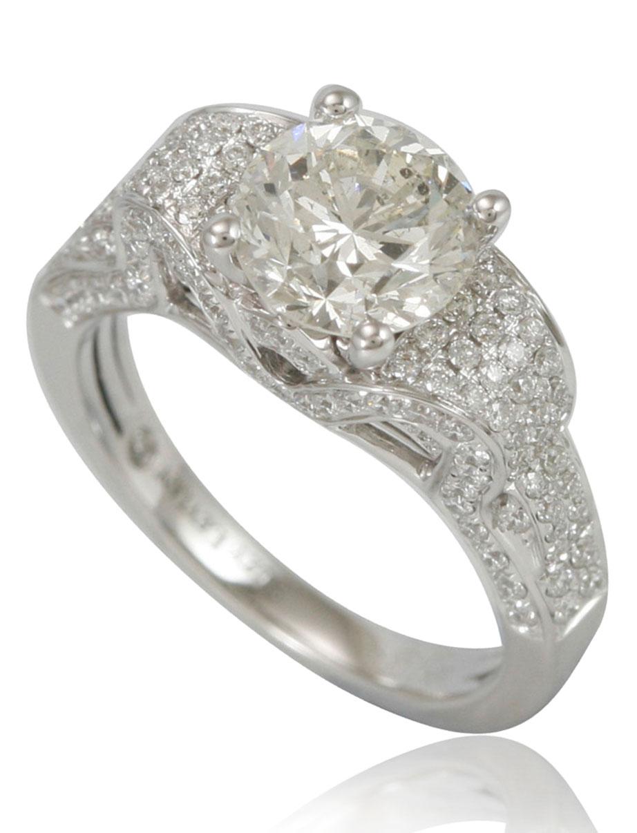 This spectacular ring from the Suzy Levian features a 18k white gold setting with a round-cut diamond center stone (2.01ct) . An array of white diamonds (.98cttw) accents the ring perfectly as the brilliance of these diamonds and the luster of the