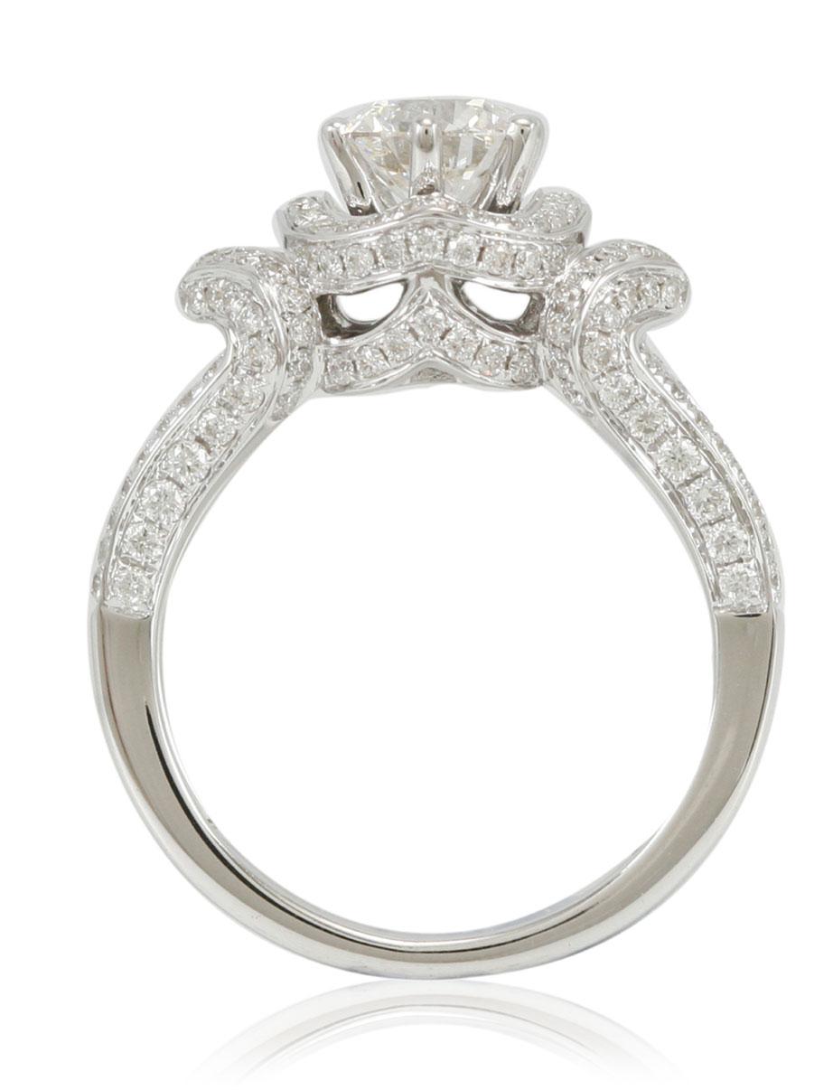Dieser spektakuläre Ring aus der Suzy Levian-Kollektion ist in 18 Karat Weißgold gefasst und mit einem runden Diamanten (1,04ct) besetzt. Eine Reihe weißer Diamanten (.88cttw) akzentuiert den Ring perfekt, da die Brillanz dieser Diamanten und der