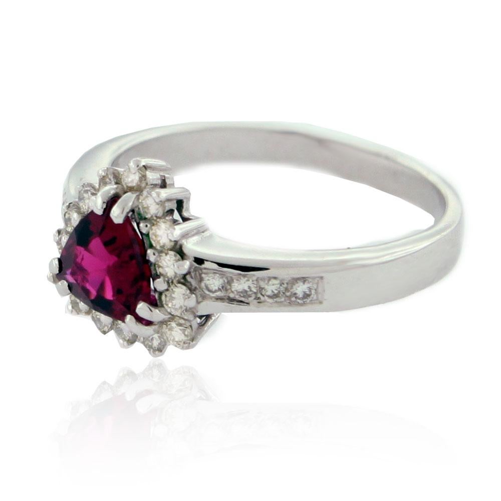 This marvelous cocktail ring from the Suzy Levian Limited Edition collection features a trillion-cut ruby center stone (1.00ct) adorned with 25 round pave white diamonds (H-I, SI1) creating a diamond halo with diamonds leading down the side of the