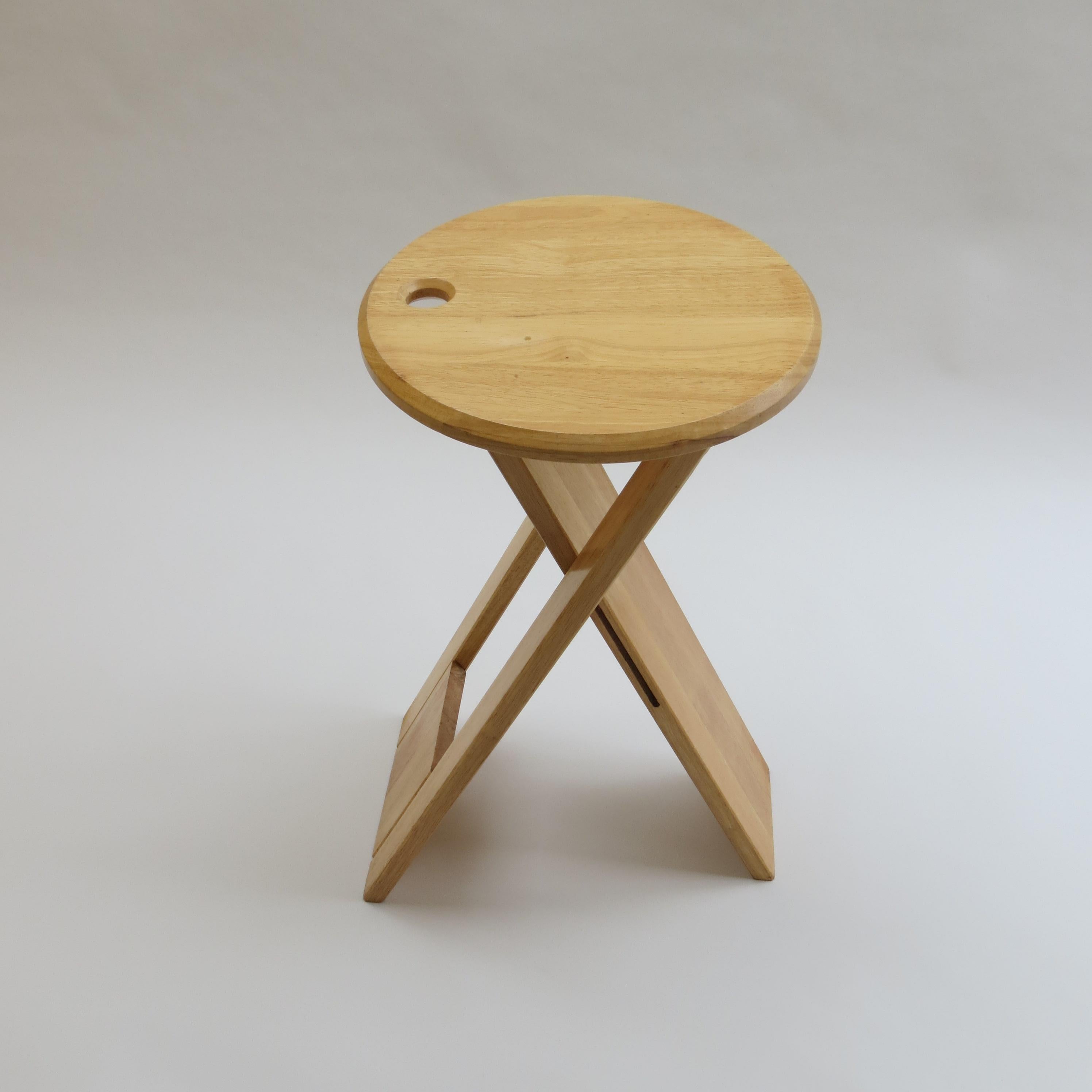 A folding Suzy stool, designed by Adrian Reed and produced by Princes Design Works in 1984/1985. 

Made from solid Deal, the stools fold and can be hung up for ease of storage. This stool does not have its original peg. It retains remnants of a