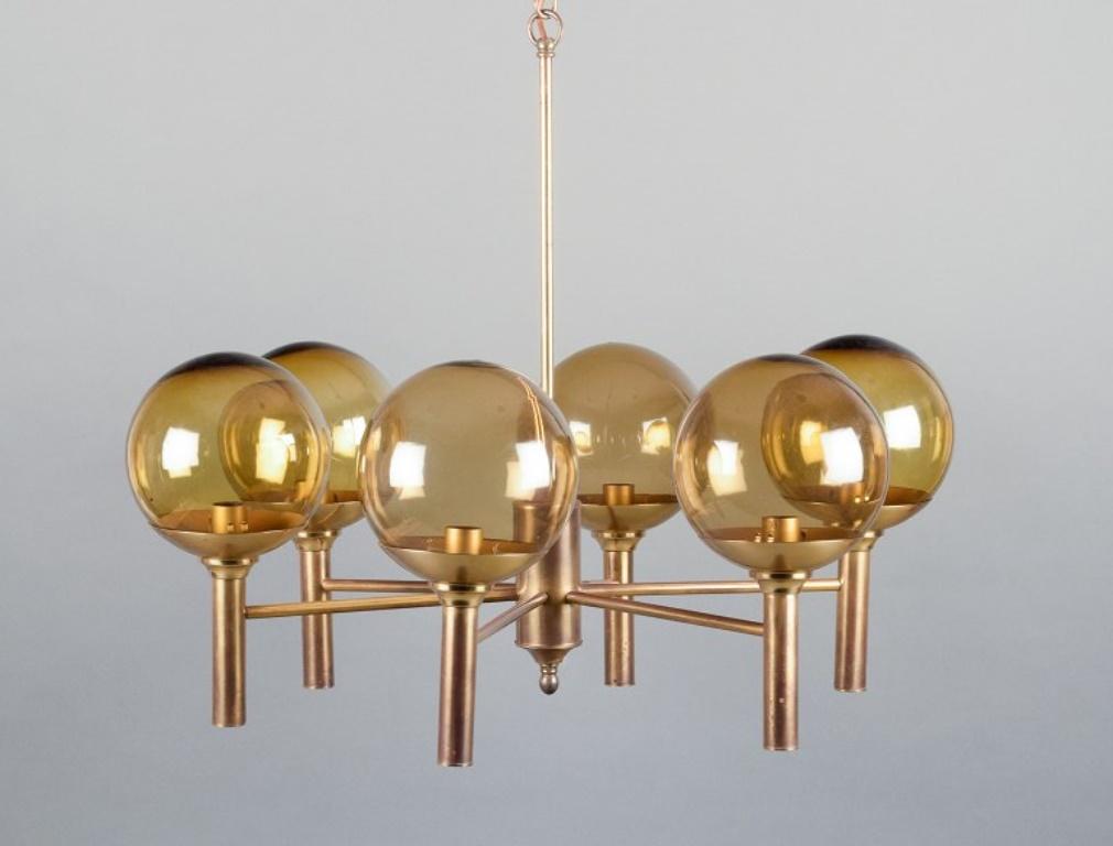 Sv. Mejlstrøm, Danish designer. 
Brass chandelier with six arms and dome-shaped shades made of amber-colored glass.
Mid-20th century.
In perfect condition.
Dimensions: H 54.0 cm x D 66.0 cm.
