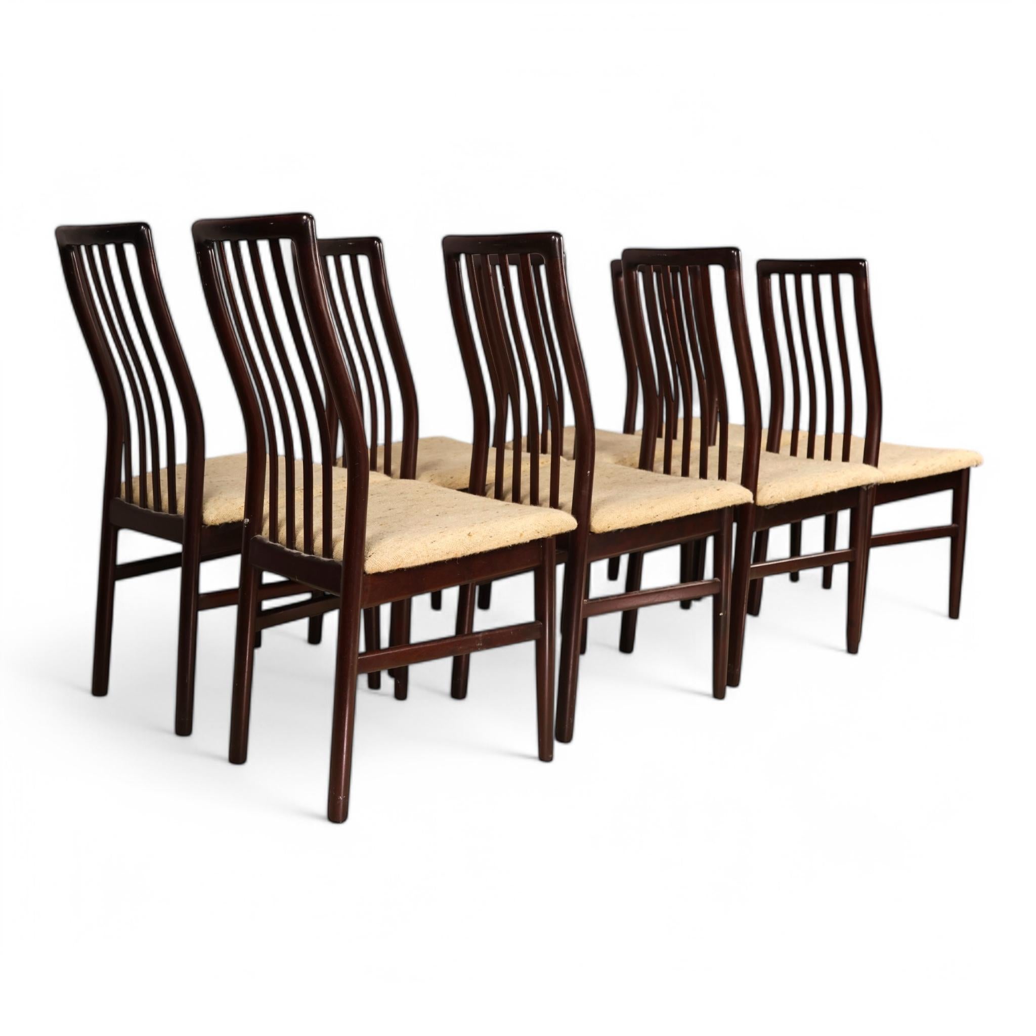 This set of eight vintage rosewood dining chairs by SVA Mobler showcases elegant Scandinavian design with a timeless appeal. Each chair features a sculptural, slatted backrest that gracefully curves to provide both aesthetic appeal and ergonomic