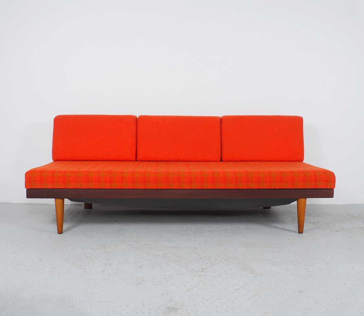 3-seater daybed or sofa bed designed by Ingmar Relling for Ekornes in the 1960s.

From the Svane series.

The teak wooden bench has a fixed mattress with 3 loose back cushions in a soft fresh orange color, the orange mattress has a motif of