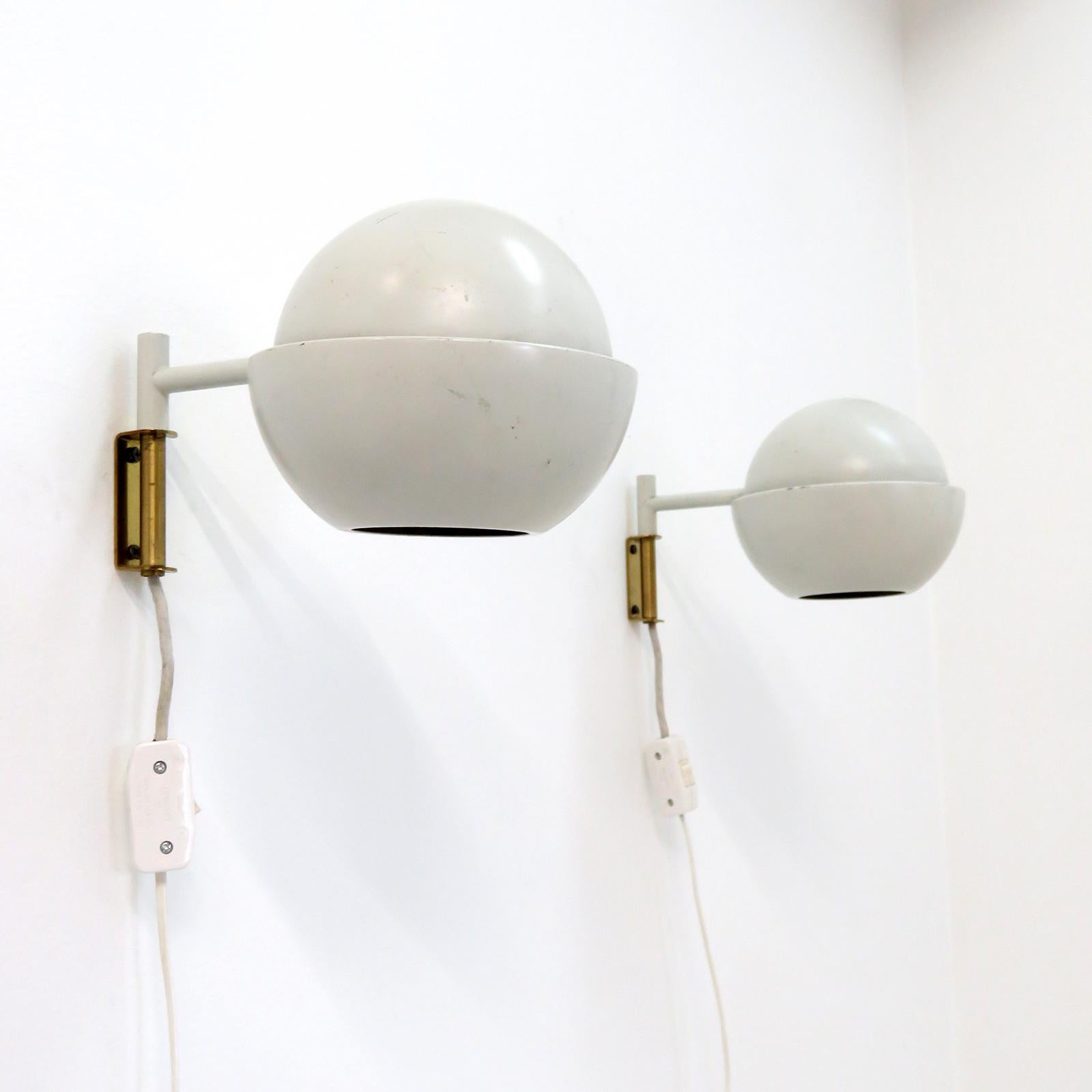 Wonderful articulate wall lights model '50-067' designed by Svea Winkler for Stockman Orno, Finland 1960, with light grey enameld sherical shade on a minimalist arm, plug in version with individual on/off in-line switch, wired for US standards, one