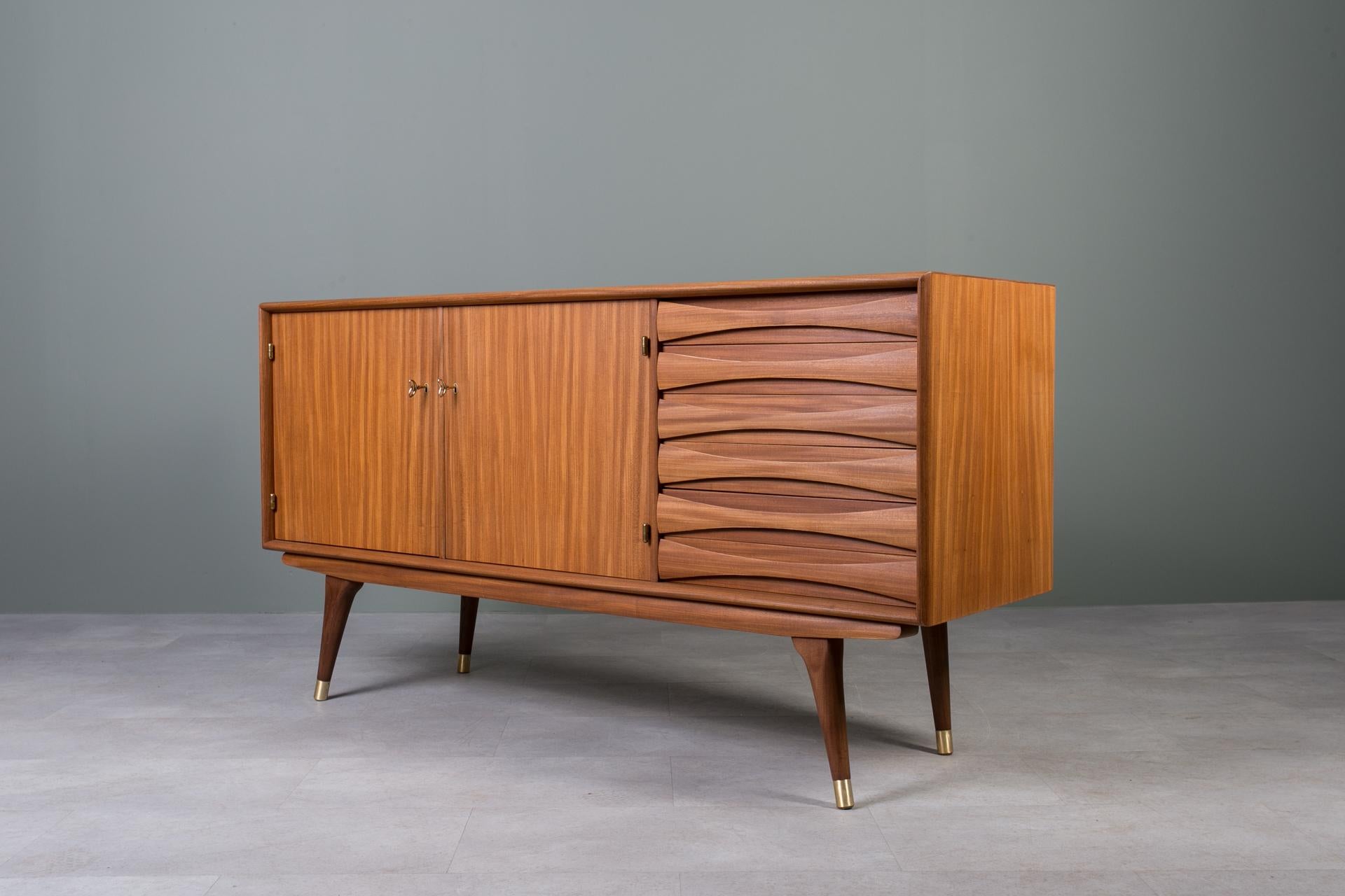 Introducing the sideboard designed by Sven Andersen – an exquisite masterpiece that seamlessly blends the timeless elegance of Scandinavian Modern design with the iconic flair of Mid Century Modern aesthetics, transporting you straight into the chic