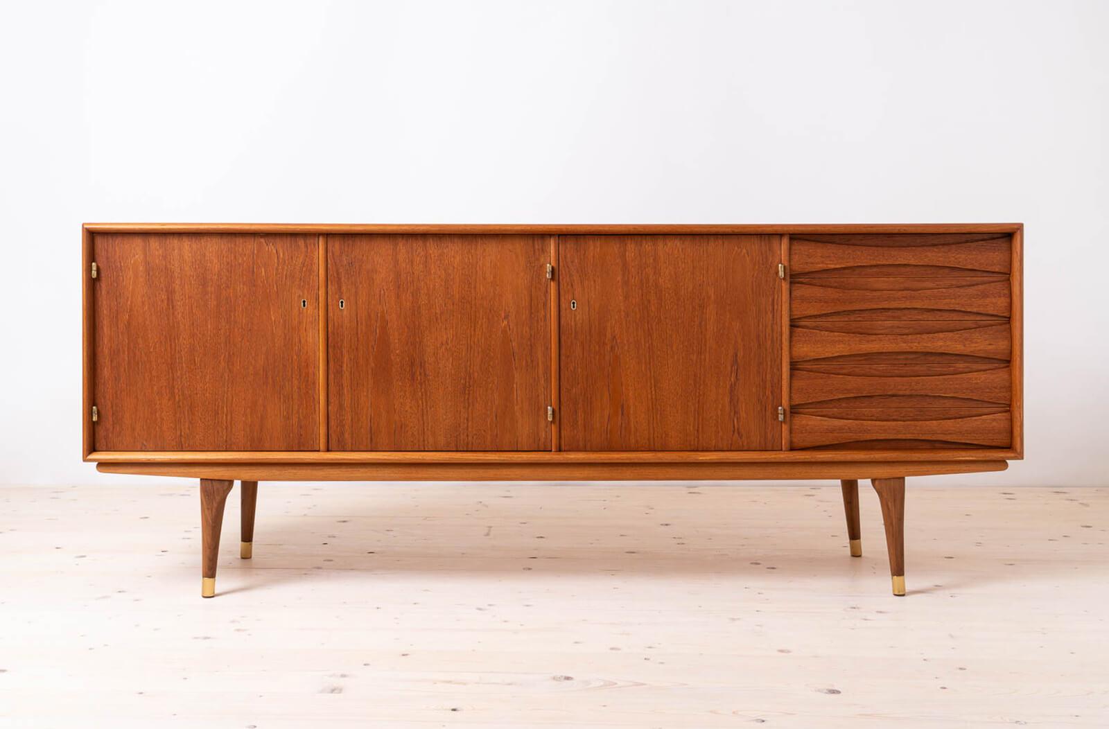 Introducing the sideboard designed by Sven Andersen – an exquisite masterpiece that seamlessly blends the timeless elegance of Scandinavian Modern design with the iconic flair of Mid-Century Modern aesthetics, transporting you straight into the chic