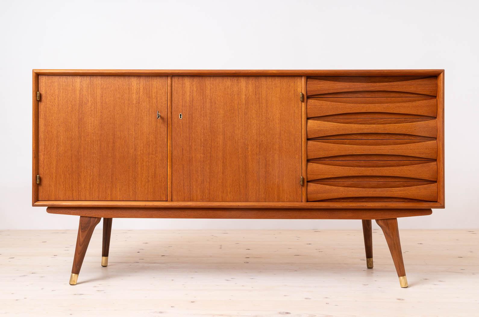 Introducing the sideboard designed by Sven Andersen – an exquisite masterpiece that seamlessly blends the timeless elegance of Scandinavian Modern design with the iconic flair of Mid Century Modern aesthetics, transporting you straight into the chic