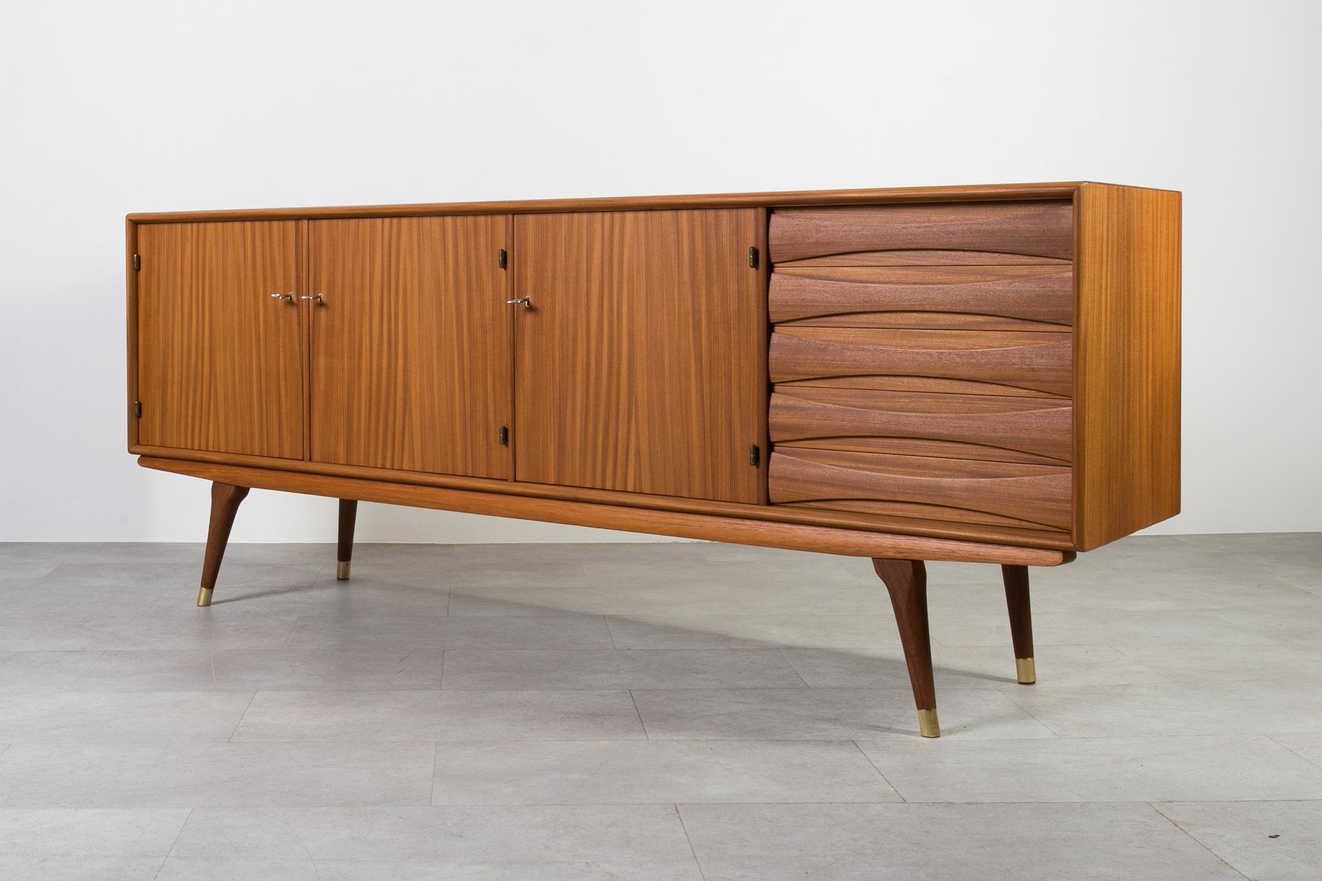 Introducing the sideboard designed by Sven Andersen – an exquisite masterpiece that seamlessly blends the timeless elegance of Scandinavian Modern design with the iconic flair of Mid Century Modern aesthetics, transporting you straight into the chic
