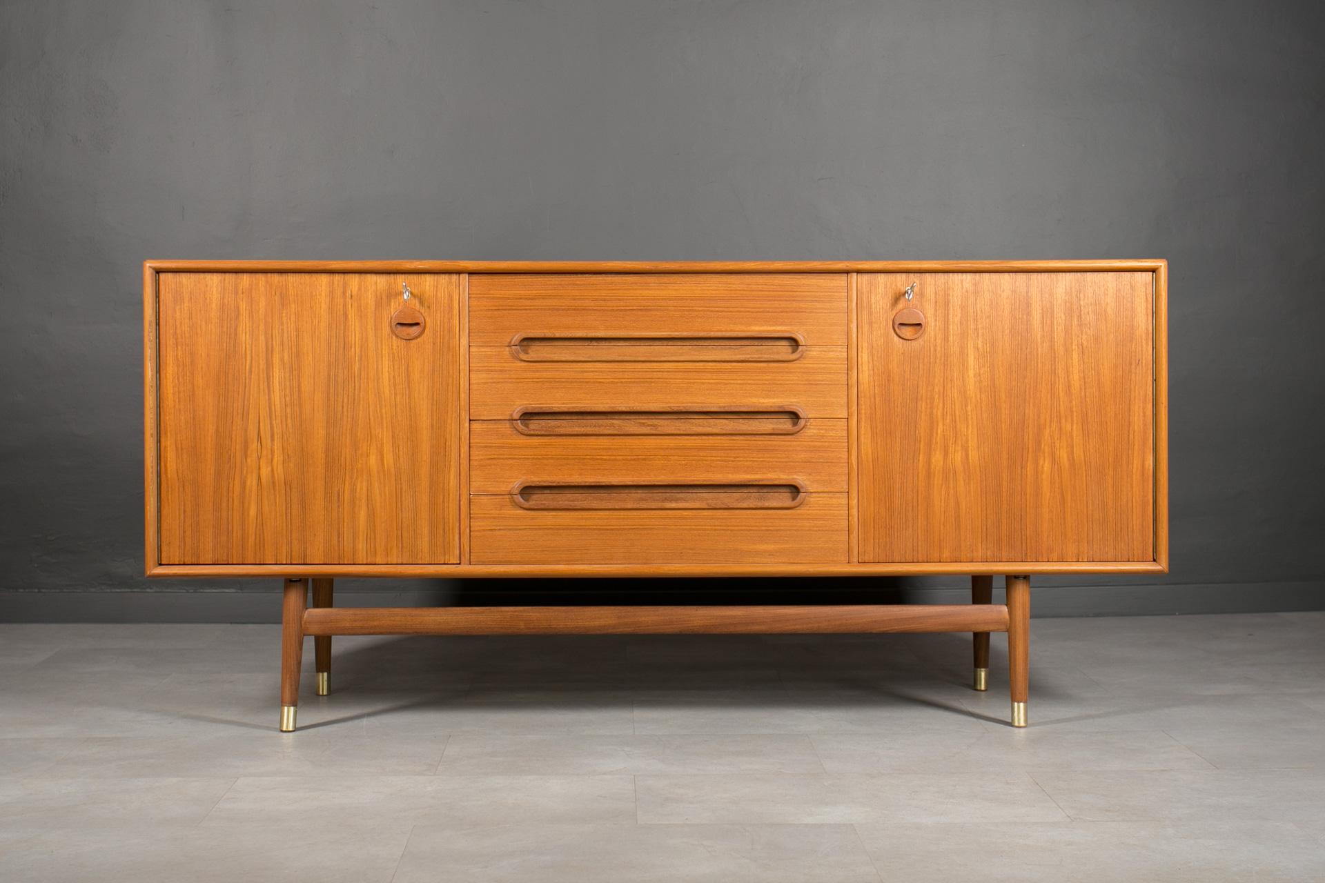 Introducing the sideboard designed by Sven Andersen – an exquisite masterpiece that seamlessly blends the timeless elegance of Scandinavian Modern design with the iconic flair of Mid-Century Modern aesthetics, transporting you straight into the chic
