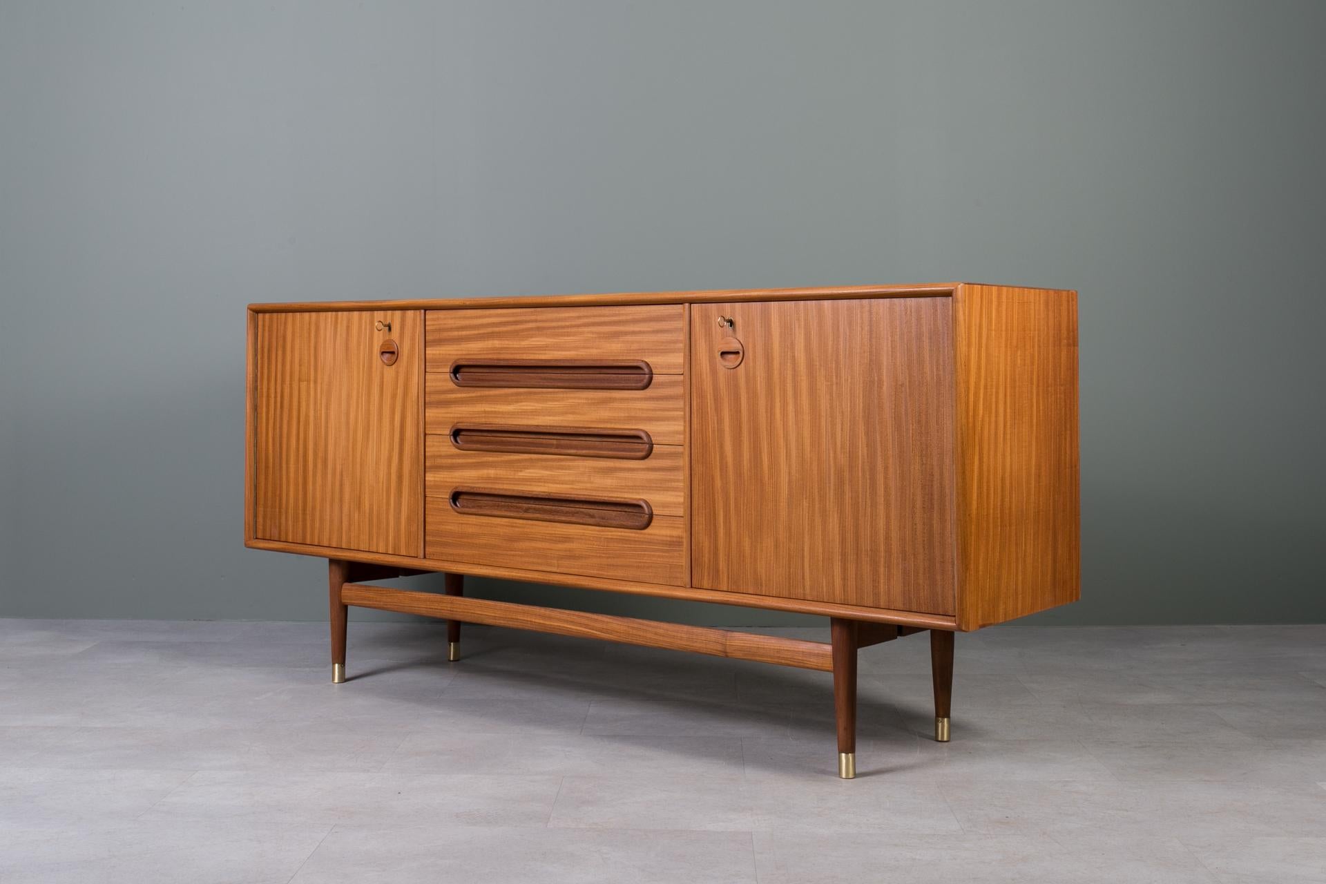 Introducing the sideboard designed by Sven Andersen – an exquisite masterpiece that seamlessly blends the timeless elegance of Scandinavian Modern design with the iconic flair of Mid-Century Modern aesthetics, transporting you straight into the chic