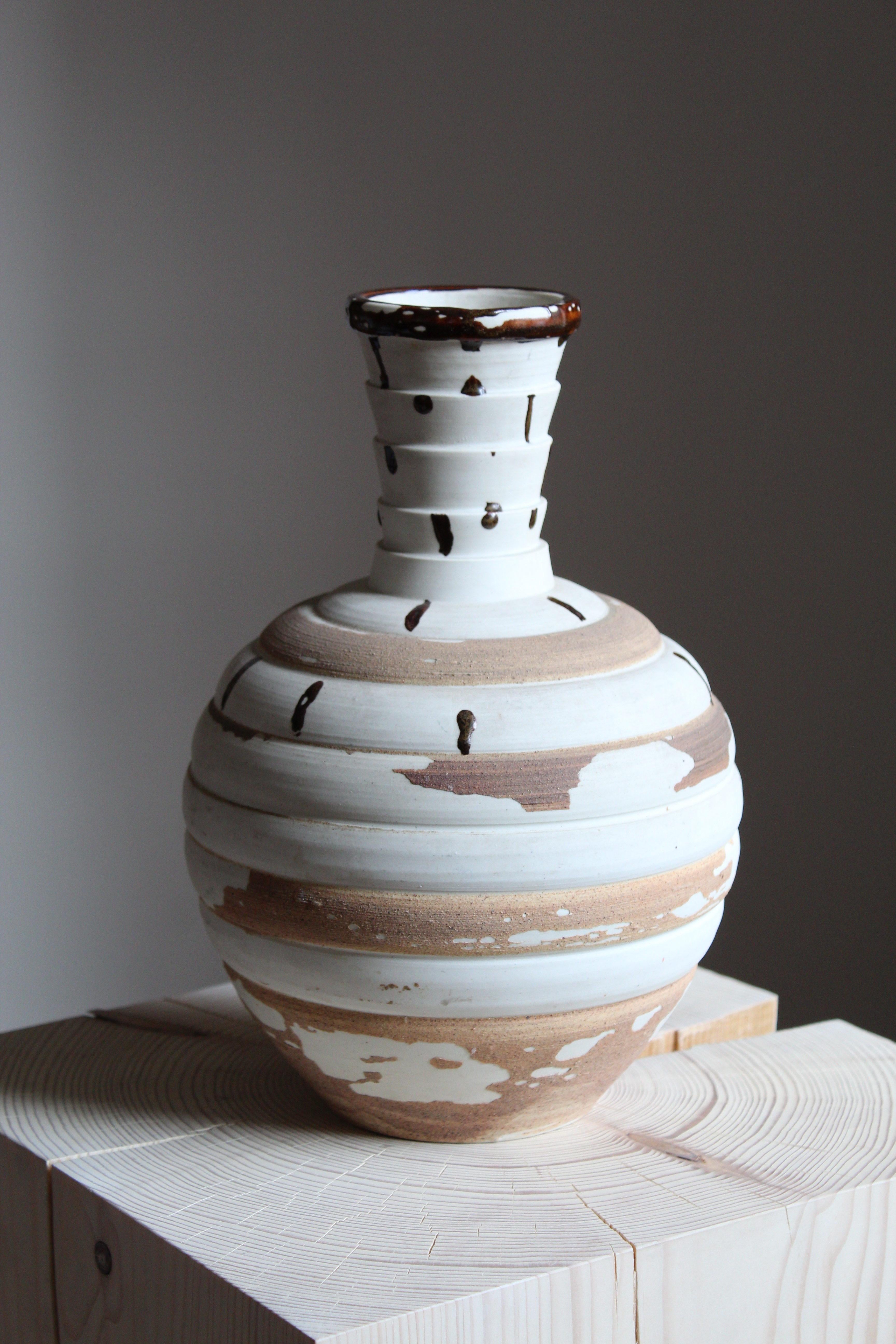 A sizable and unique stoneware vase. Executed by Sven Bolin (1921-1996) for Höganäs, circa 1960s

Features a complex multi-layer glaze where unglazed stoneware has been applied to the glazed stoneware and partially deconstructed. Features