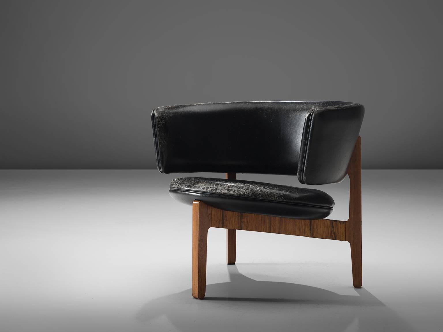 Sven Ellekaer for Christian Linnenberg's Møbelfabrik, lounge chair in rosewood and black leather, Denmark, design 1962.

This piece, featuring a semi-circular back was designed in 1962 together with a small range of accompanying furniture. The