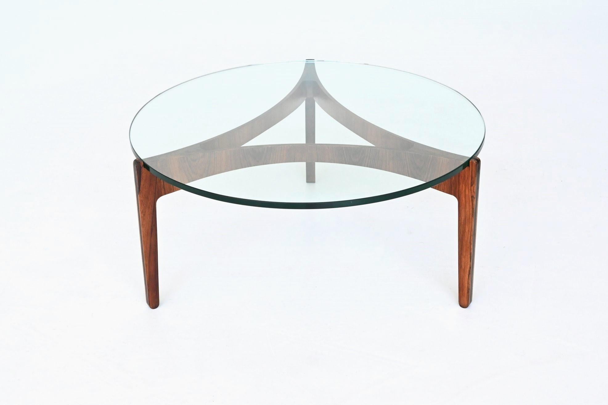 Stunning sculptural coffee table model 104 designed by Sven Ellekaer for Chirstian Linneberg, Denmark 1962. This exquisite coffee table is composed of a beautiful elegant bent rosewood base highly figured grain which supporting a thick transparent