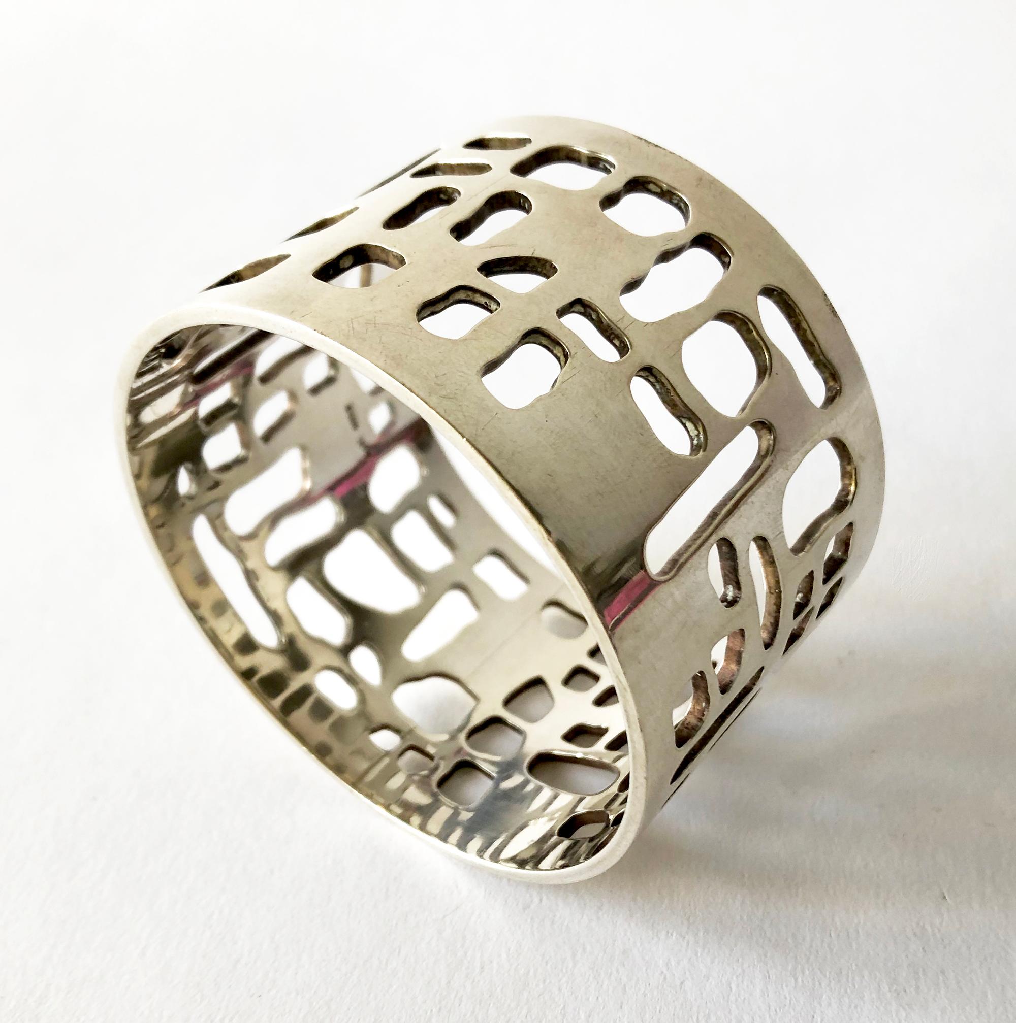 Sterling Silver bangle bracelet with abstract perforations created by Sven Haugaard of Denmark.  8.5