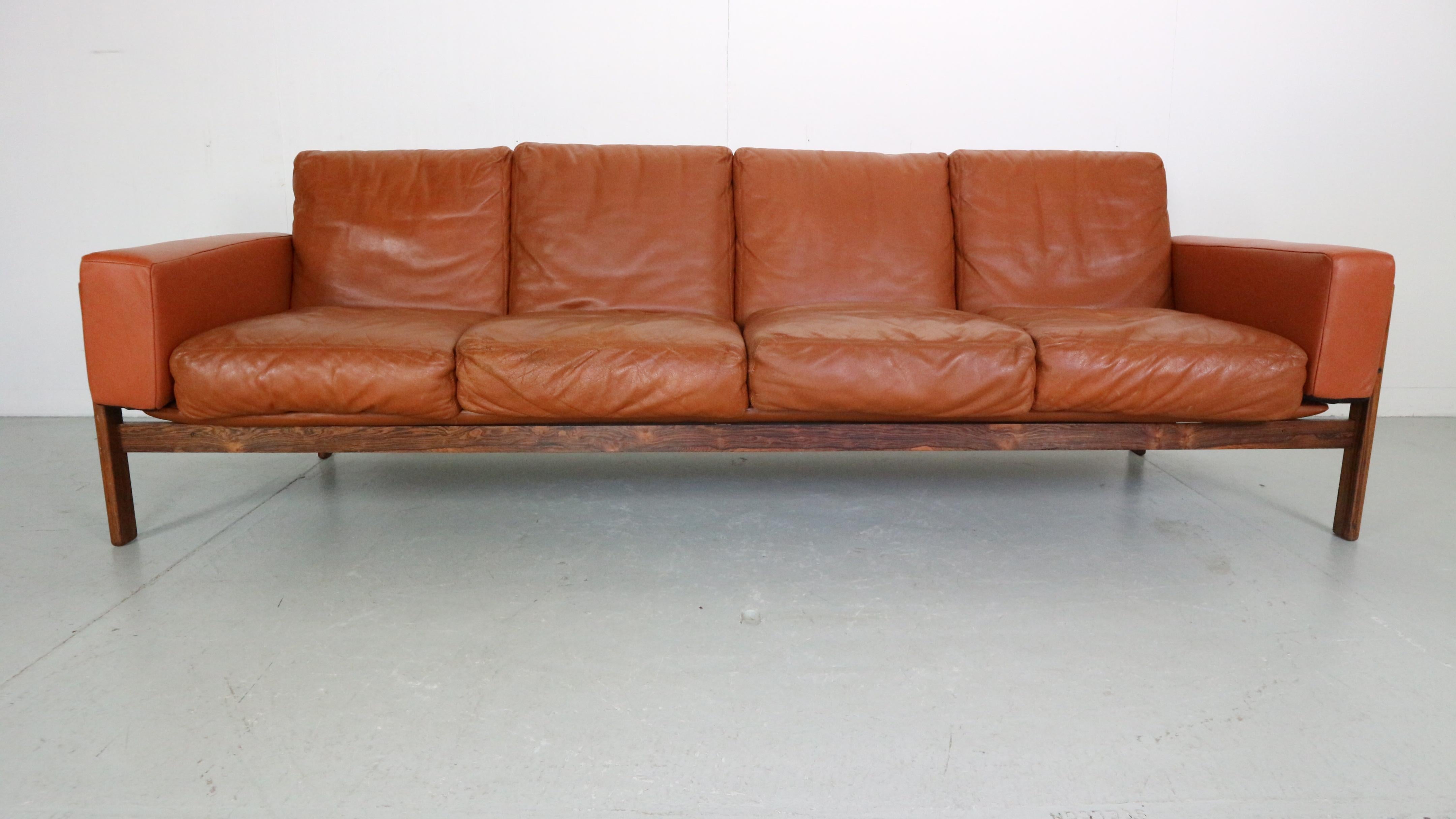 Rare vintage Norwegian design 4-seater wood and leather sofa, model Flueline. Designed by Sven Ivar Dysthe for Dokka Møbler in the 1960s.

This iconic design piece has eight loose cushions, and two armrest cushions in gorgeous cognac/camel-colored