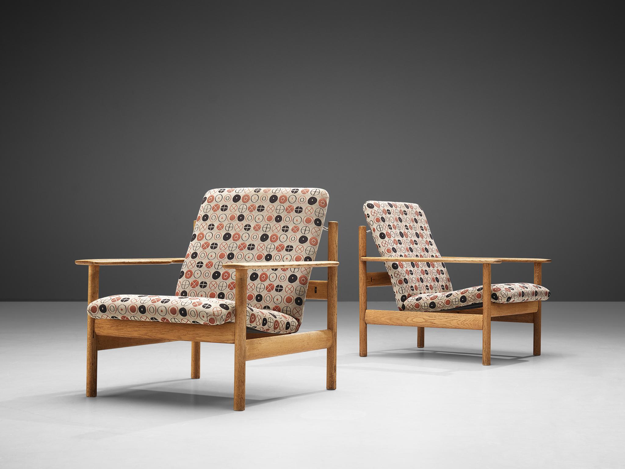 Sven Ivar Dysthe for Dokka Møbler, pair of lounge chairs model 1001, oak, fabric upholstery, Norway, 1960
Charles and Ray Eames, patterned fabric 'Circles', manufacturerd by Maharam, design 1947

This set of lounge chairs is designed by Sven Ivar
