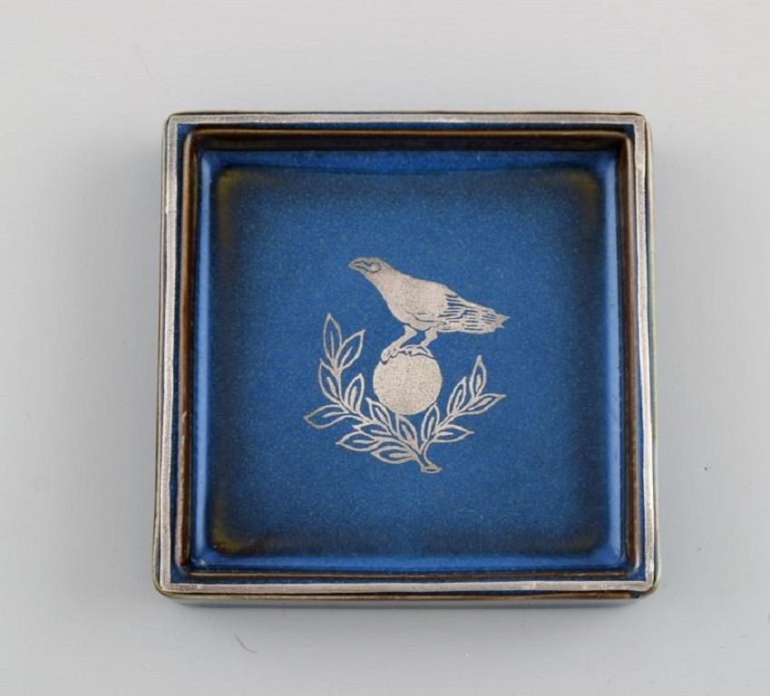 Sven Jonson (1919-1989) Gustavsberg. 
Tres pequeños platos Lagun de gres vidriado con incrustaciones de plata. 
Precioso vidriado en tonos azules. 1970s.
Medidas: 9 x 9 x 1,5 cm.
En excelente estado.
Sellado.