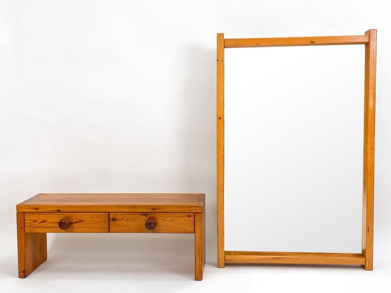 Step into the golden era of Scandinavian design with the Sven Larsson Danish Mid-Century Pine Hall Mirror & Petite Chest/Bench. A true embodiment of the 1970s Nordic aesthetic, this ensemble seamlessly marries form and function in a dance of pine