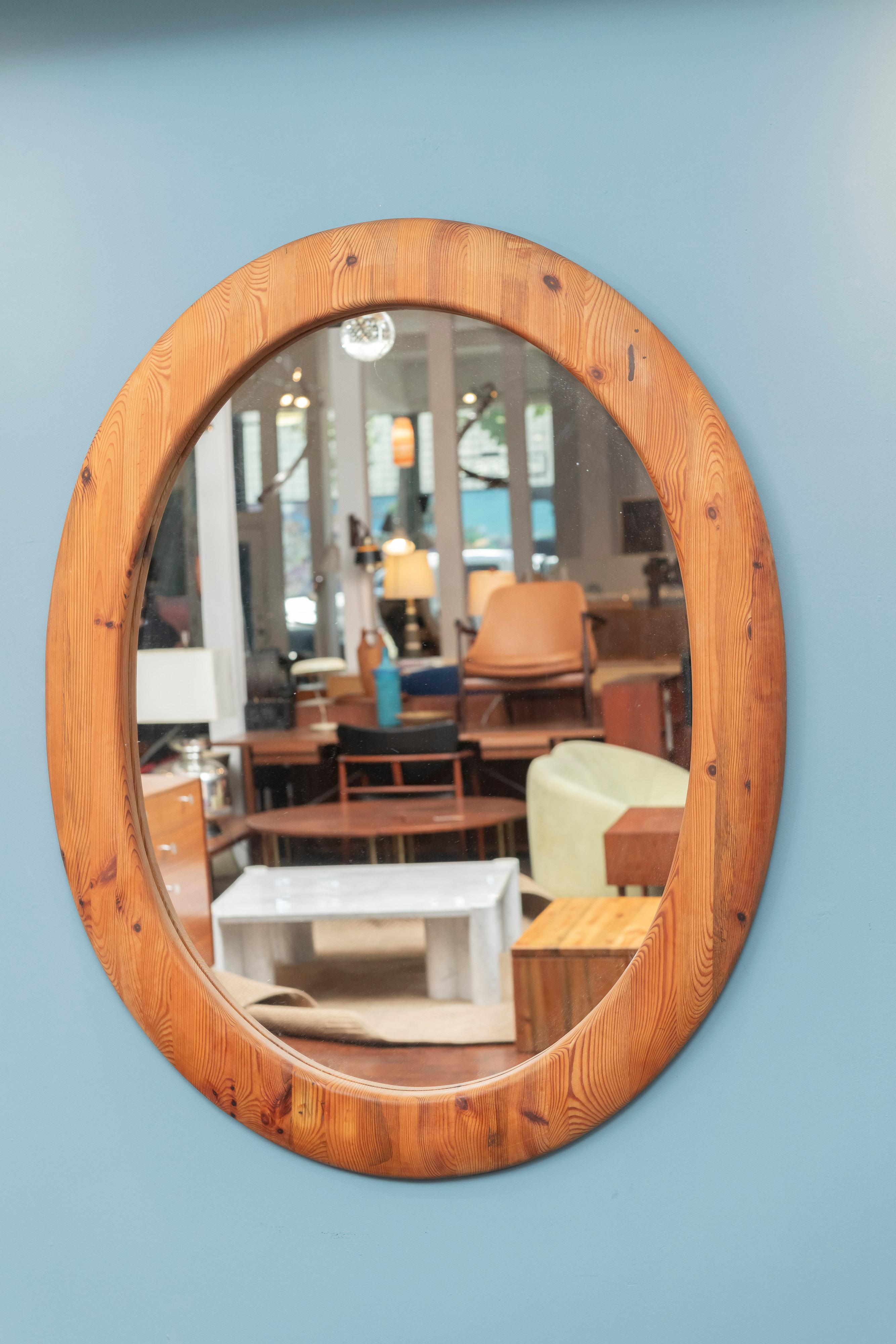 Large Sven Larsson design solid pine oval wall mirror with matching bench. Impressive in size and scale with a matching bench that makes it perfect for an entry way or dressing room. The oval frame is rounded or domed with beautiful wood grain