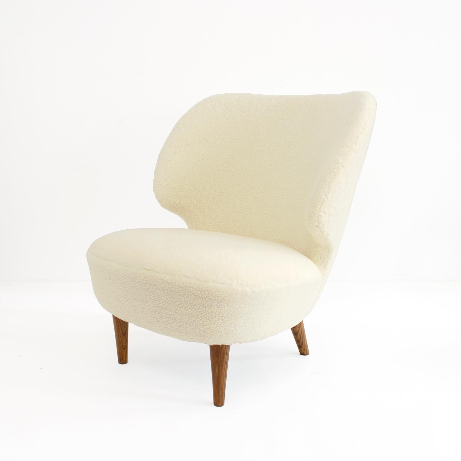 Sven Staaf’s 1940s wingback lounge chair upholstered in faux sheepskin upholstery. The chair’s broad backrest is comfortable and enveloping, the solid elm wood dowel legs are newly restored. Made by Almgren & Staaf, Sweden

Measures: Height: