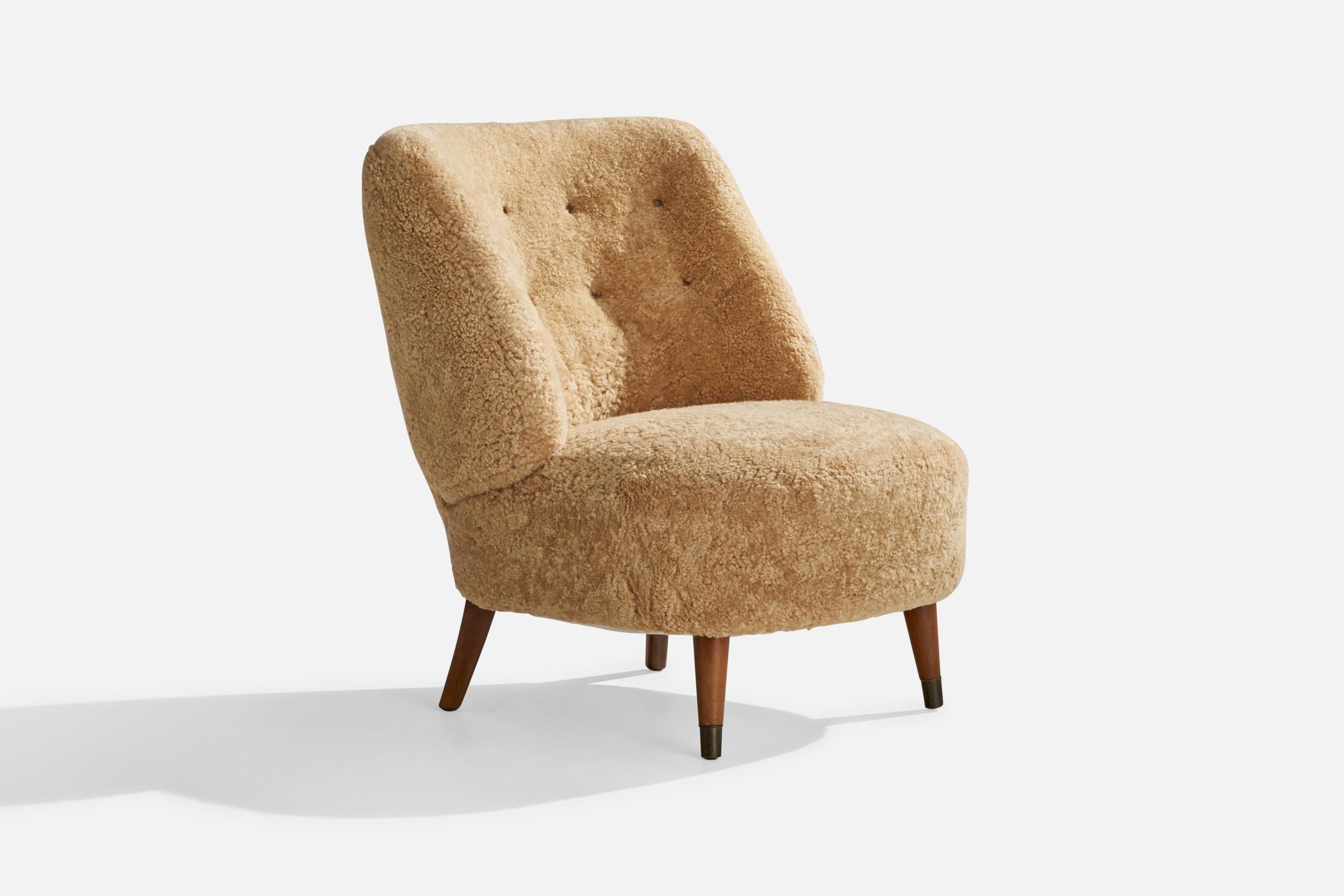 A beige shearling, wood and brass lounge chair designed and produced by Sven Staaf, Sweden, 1940s.

seat height 16.5”.