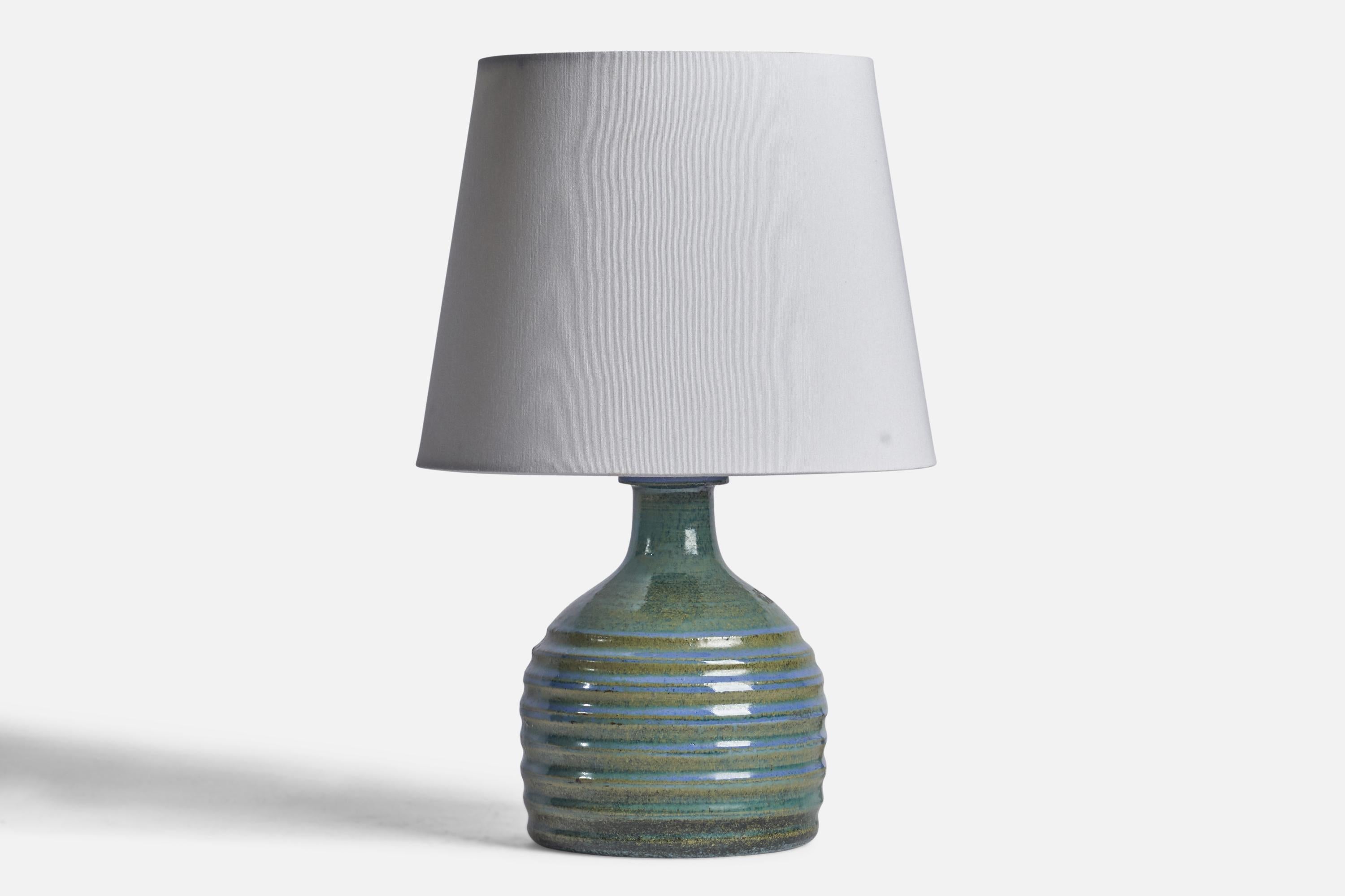 A blue-glazed and incised stoneware table lamp designed by Sven Wejsfelt and produced by Gustavsberg, Sweden, 1974.

Dimensions of Lamp (inches): 9.75” H x 6” Diameter
Dimensions of Shade (inches): 7.6” Top Diameter x 10” Bottom Diameter x 8”