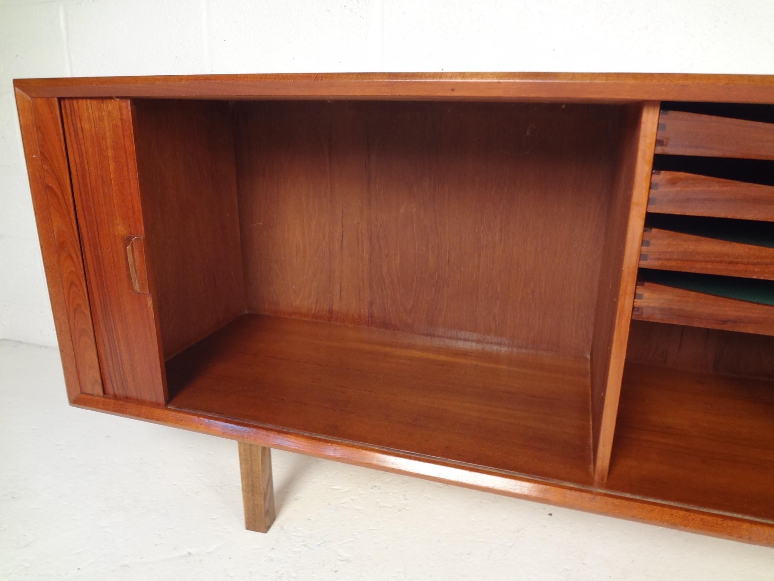 Long mid-century server by Svend A. Larsen with receding tambour doors. Left and right cabinet space and middle drawer storage. 
Please confirm location.