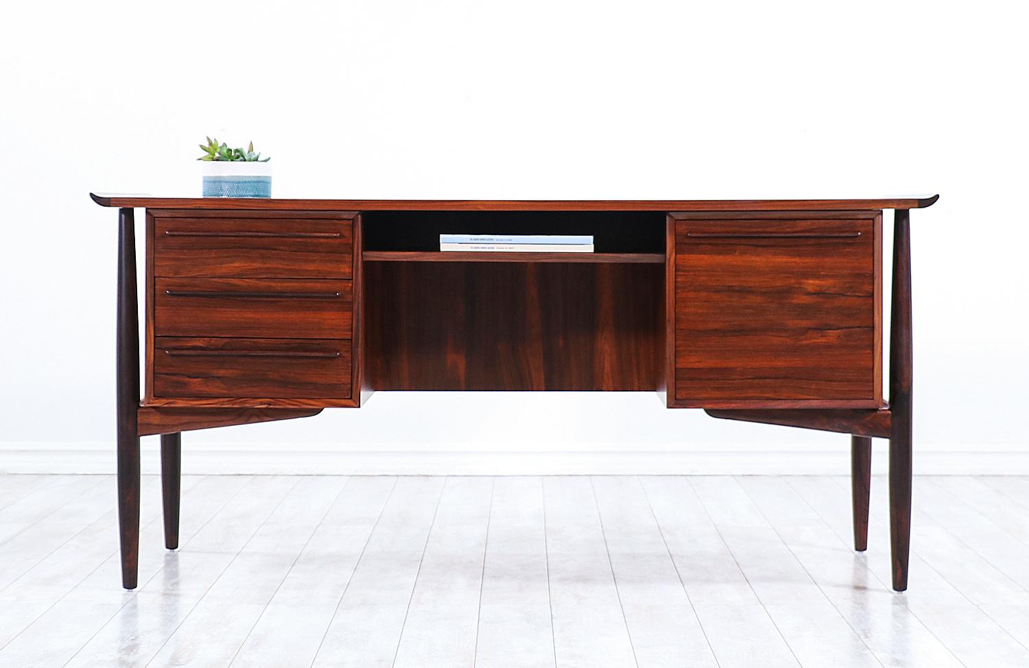 Vintage executive desk designed by Svend A. Madsen and handcrafted by H.P. Hansen Møbelindustri's workshop in Denmark, circa 1950s. This Danish Modern design is beautifully crafted in Brazilian rosewood and features three spacious drawers on the