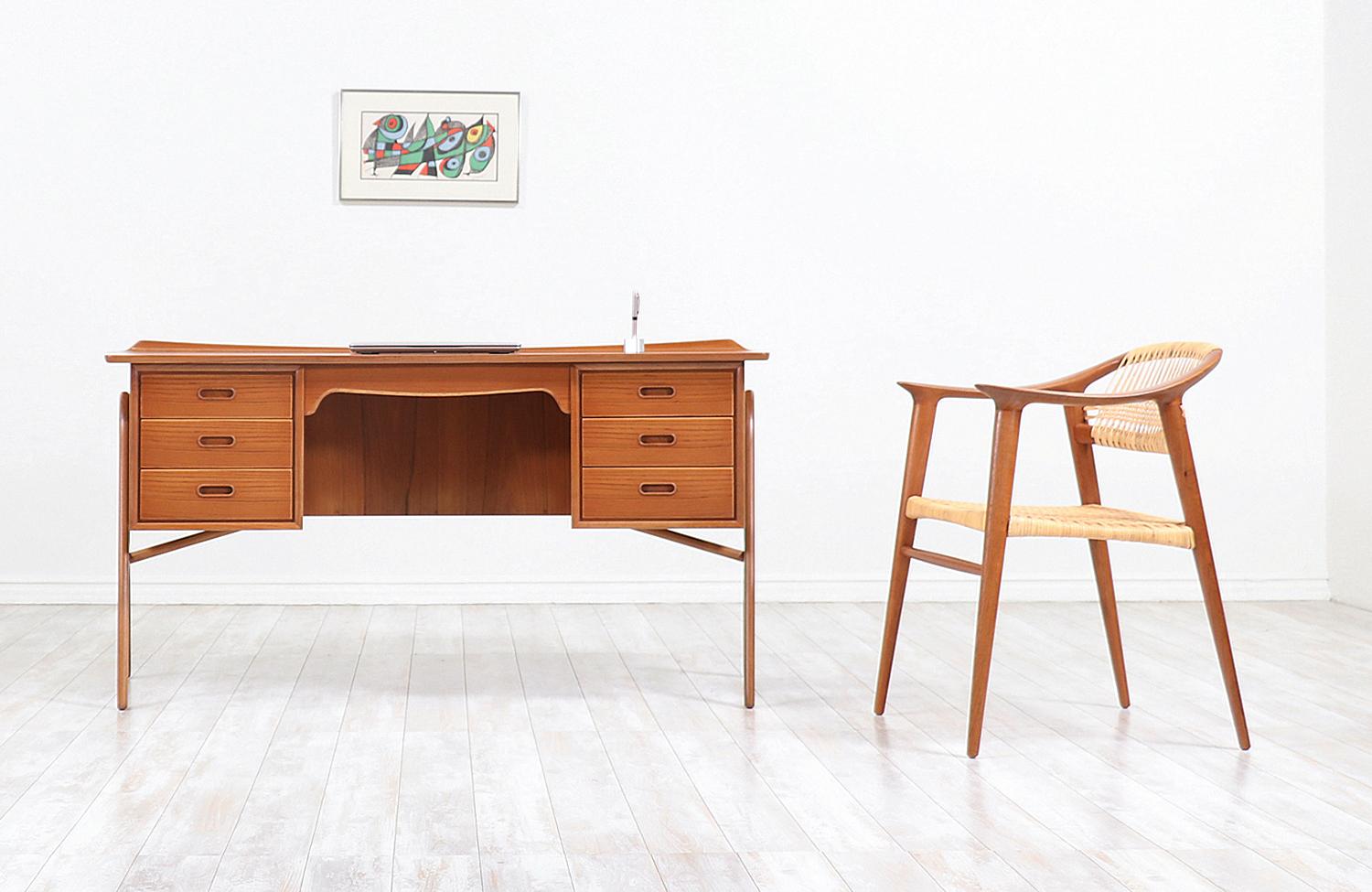 Striking executive desk designed by architect Svend A. Madsen for H.P. Hansen Møbelindustri in Denmark circa 1960s. This iconic design is meticulously crafted in teak wood and is suspended in boomerang legs epitomizing Madsen’s minimal and classic