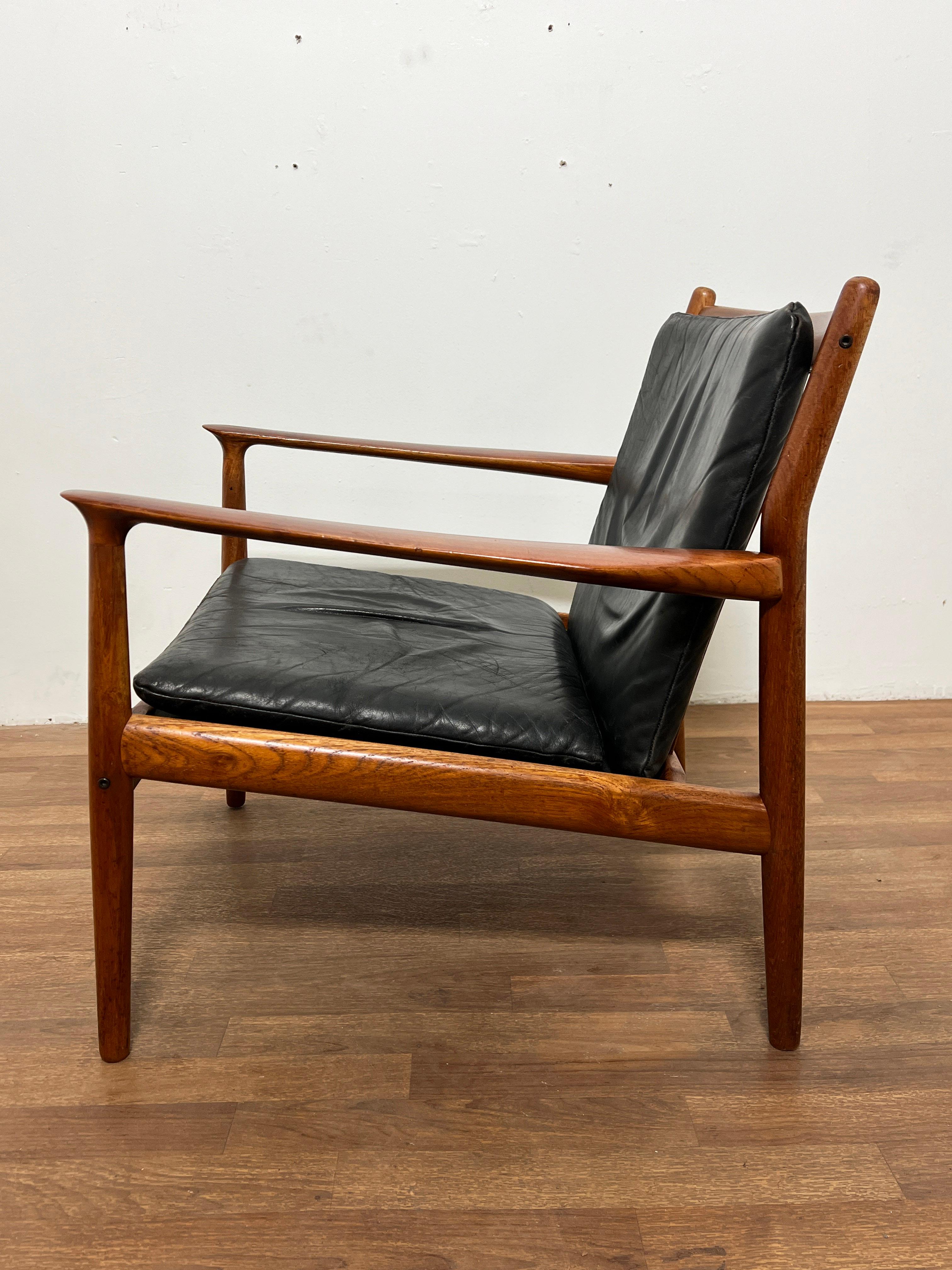 Ein dänischer Loungesessel aus Teakholz mit originaler weicher Lederpolsterung, entworfen von Svend Aage Eriksen für die Glostrup Mobelfabrik, in Anlehnung an Grete Jalk, die ebenfalls für Glostrup entwarf.

A passend  Das dreisitzige Sofa ist in