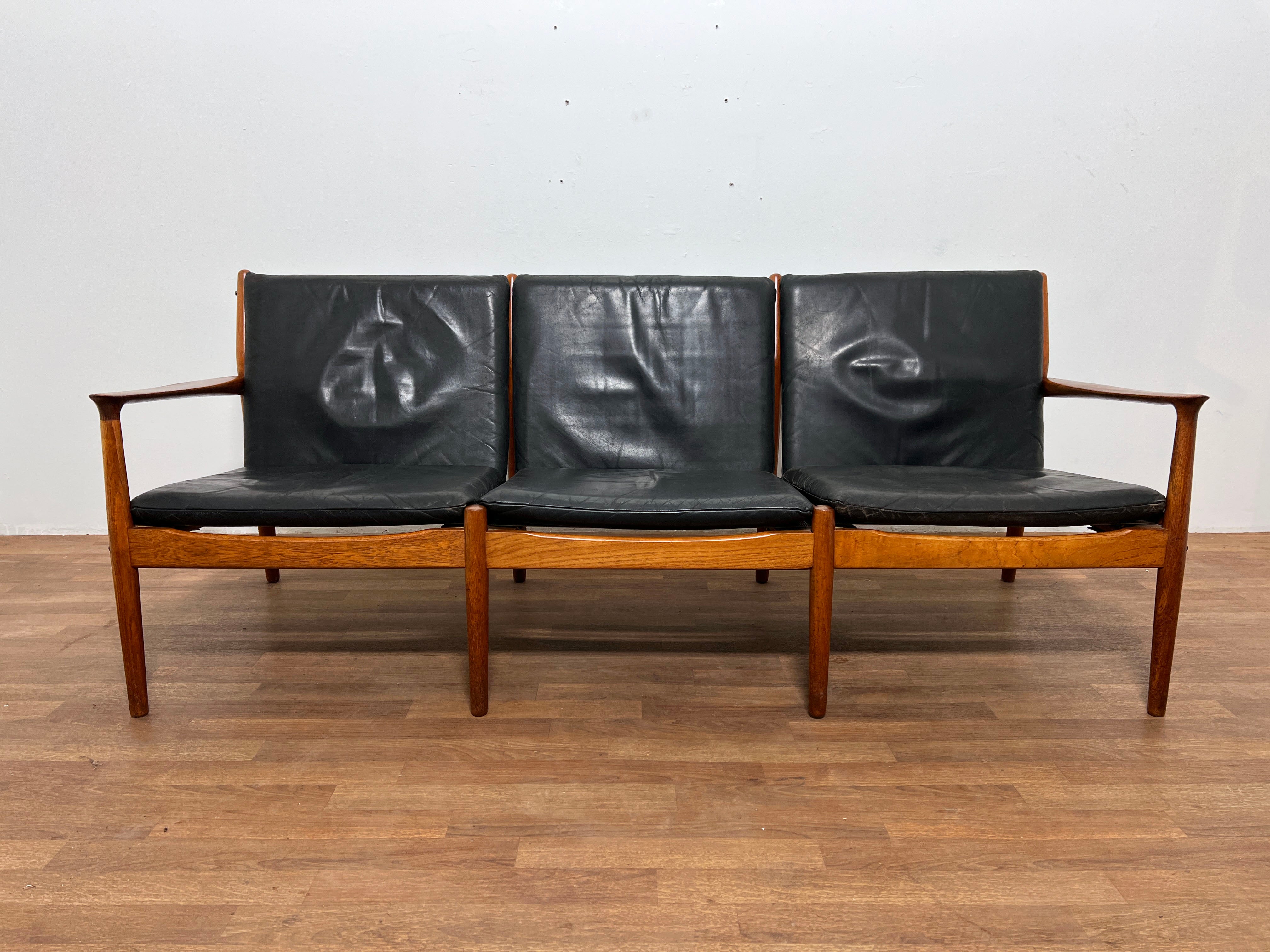 Ein dänisches Dreisitzer-Sofa aus Teakholz mit originaler weicher Lederpolsterung, entworfen von Svend Aage Eriksen für die Glostrup Mobelfabrik, in der Art von Grete Jalk, die ebenfalls für Glostrup entwarf.

Ein passender Loungesessel ist in einem