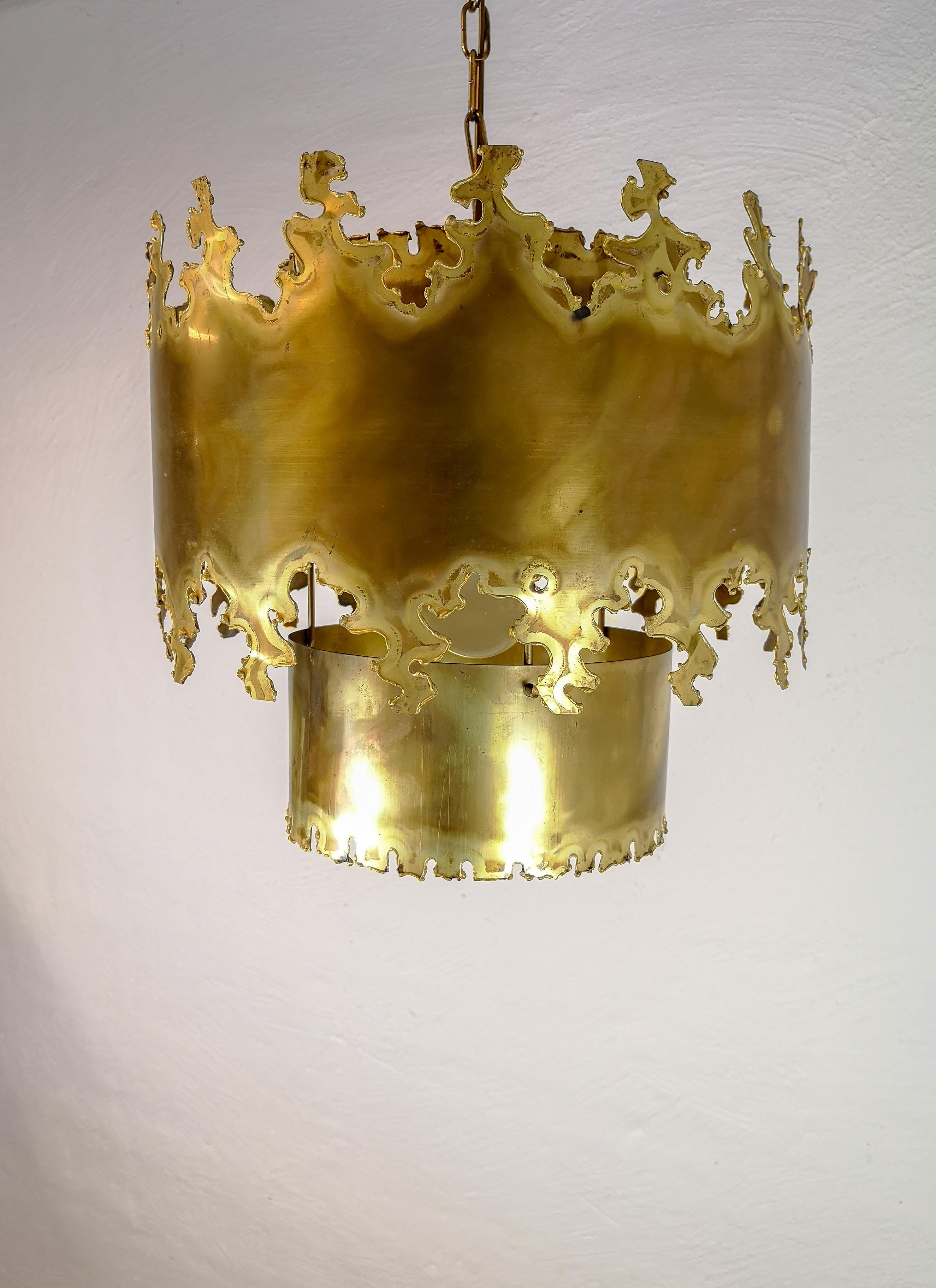 This large beautiful pendant made in brass is made in Denmark for the company of Holm Sorensen & Co in the 1960s.
Its has a brutalist style in the way the Designer has created the brass cut in the pendant. Type Nr. 6399 Brass Pendant. 

Good