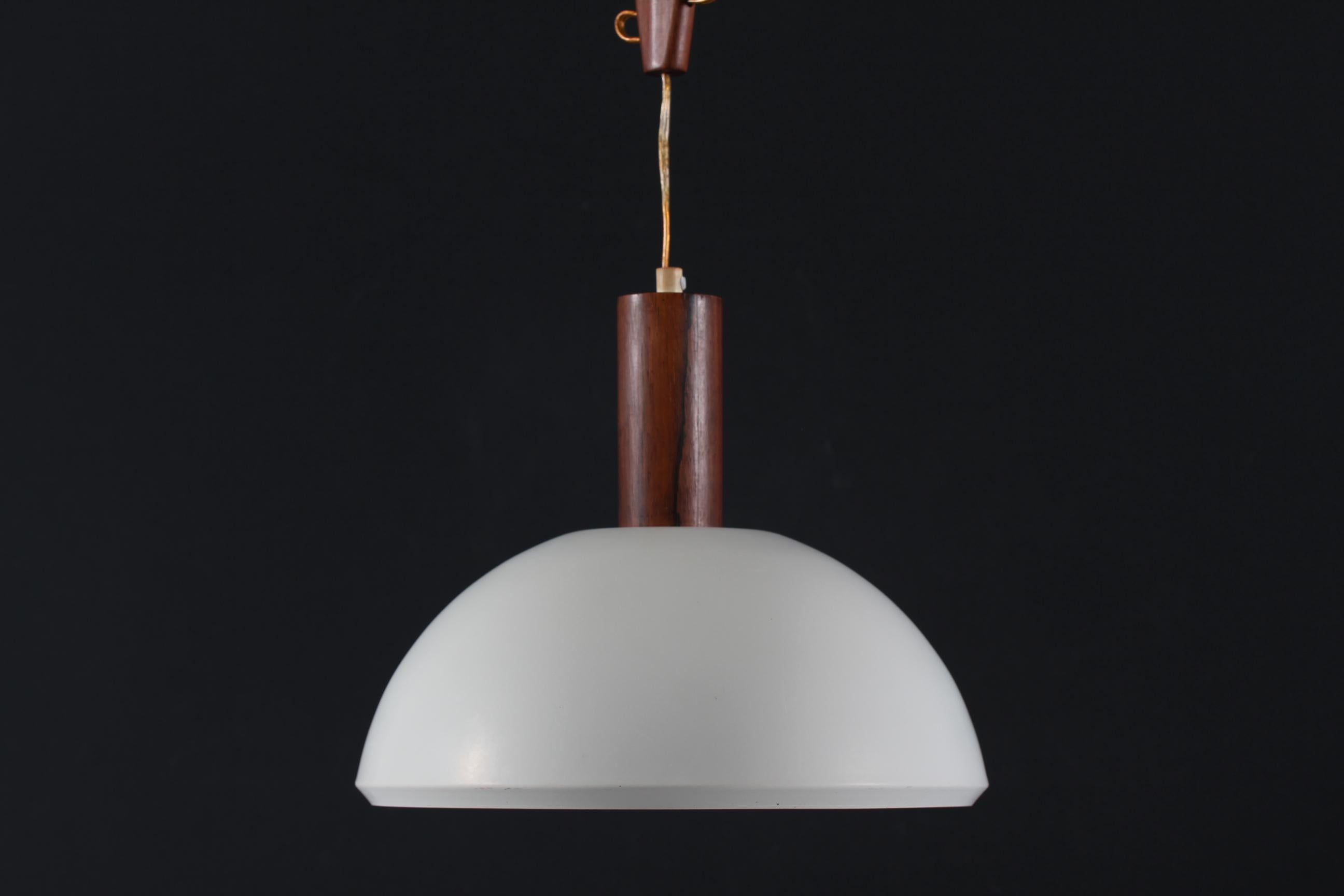 Rare Danish vintage ceiling lamp/pendent light designed by Svend Aage Holm Sørensen, with adjustable stem made of rosewood. The shade is made of metal with matte white lacquer and with a plastic grid.
Made in Denmark mid-century

Measures: