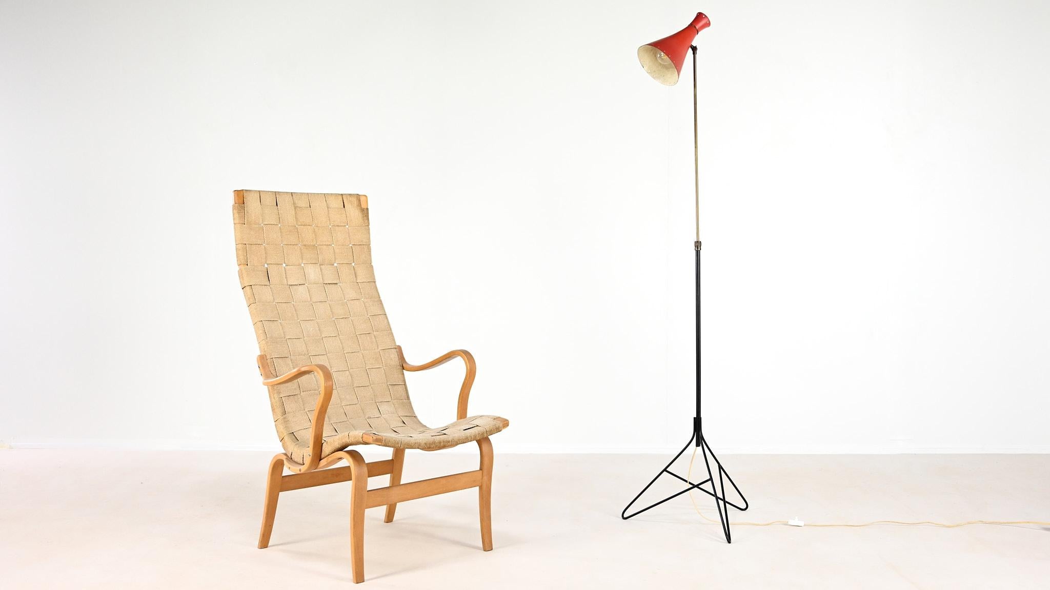 A rare tripod floor lamp, attributed to Svend Aage Holm Sørensen. It consists in a red “diabolo”, or “cocotte”, orientable reflector mounted on a brass and black lacquered tubular steel minimalist tripod base, adjustable in height. Patina of time