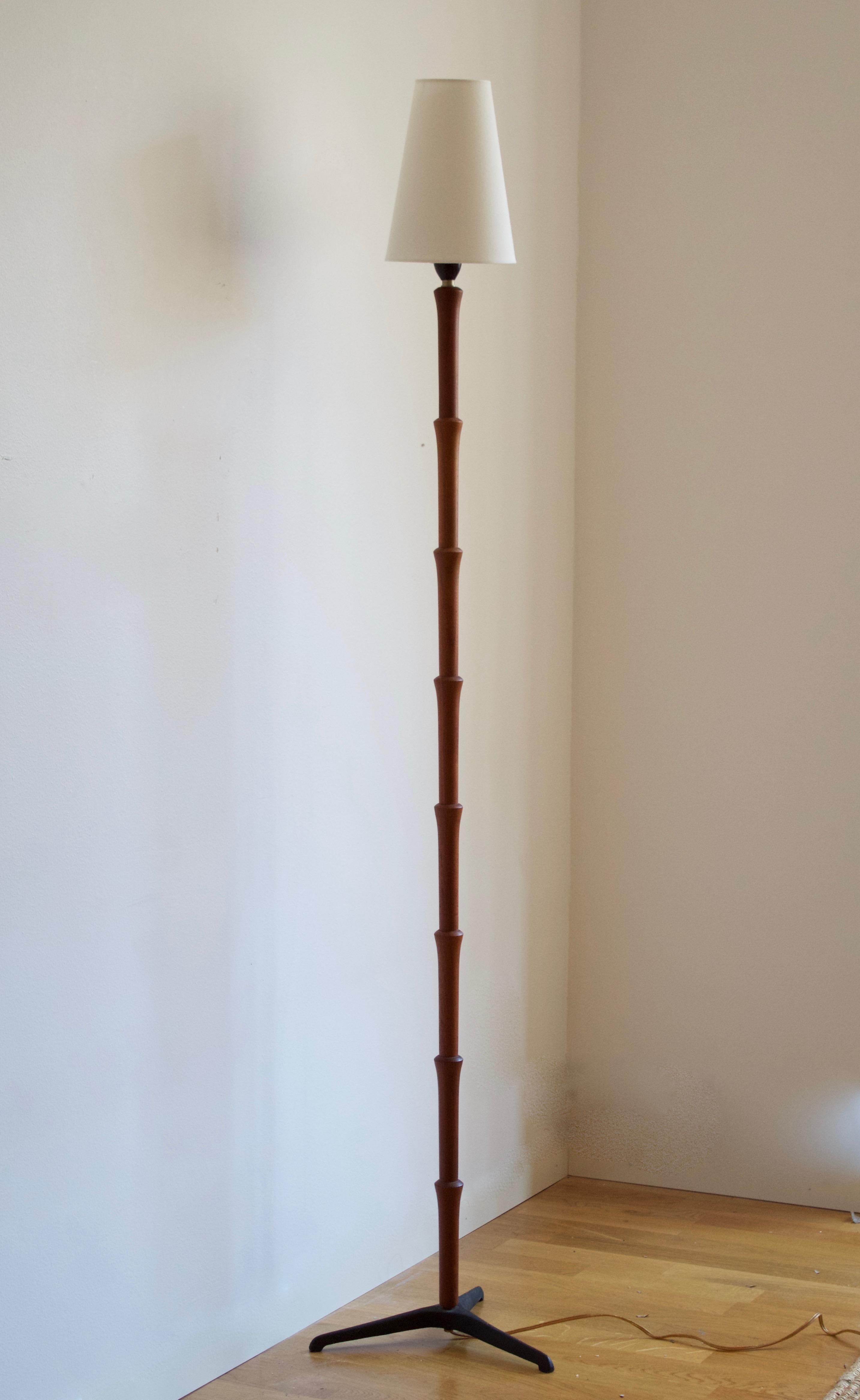 An adjustable modernist floor lamp, design attributed to Svend Aage Holm Sørensen, Denmark, 1950s. Adjustable in height. Brand new lampshade.

In teak, black painted cast iron foot.

Other designers of the period include Paavo Tynell, Serge