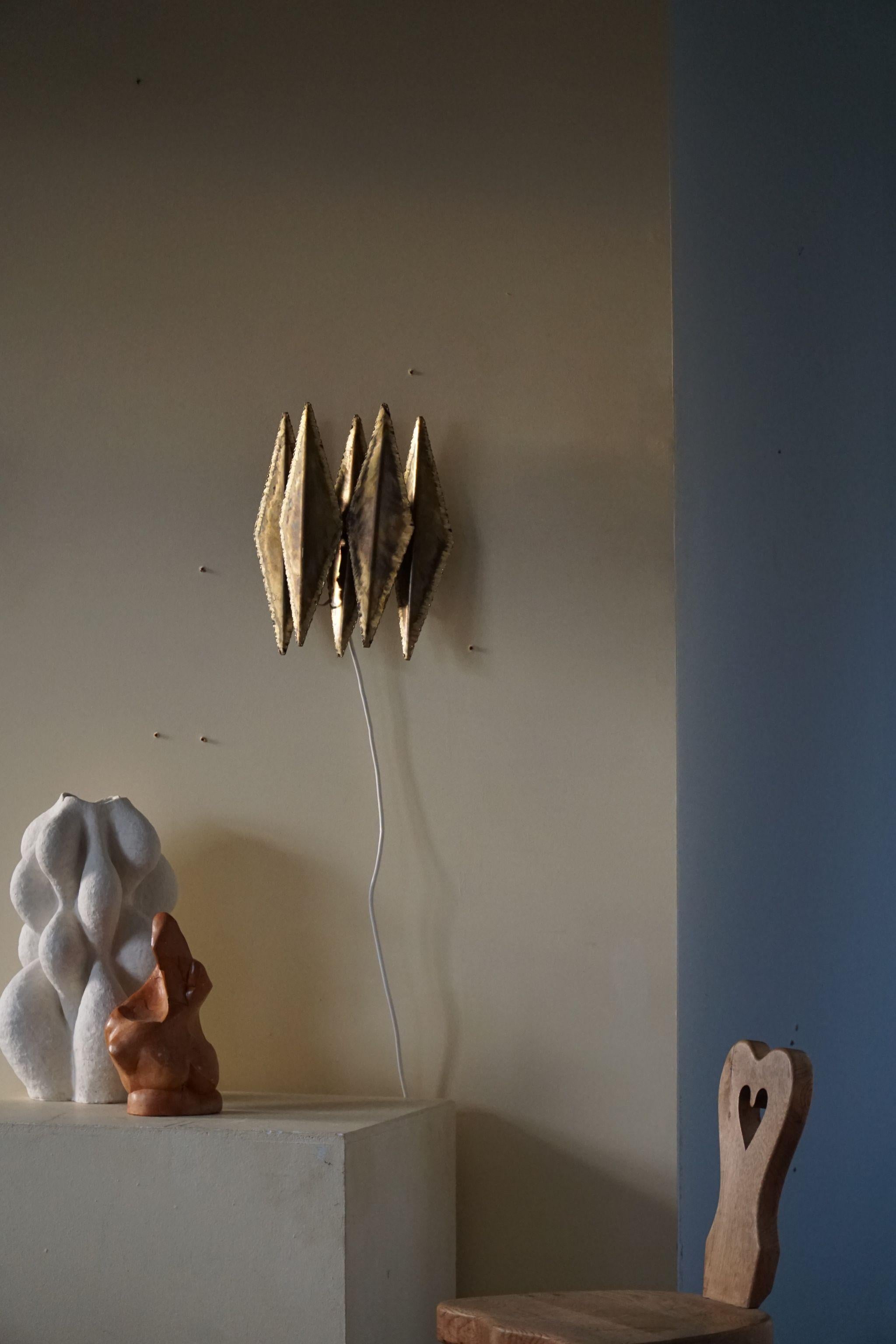 Danish modern brutalist wall unit light, made by Svend Aage Holm Sørensen in 1960s.
The brass petals are torch cut and acid treated for effect - Holm Sorensen's signature method. The piece comes with original brass chain. 

Overall good vintage