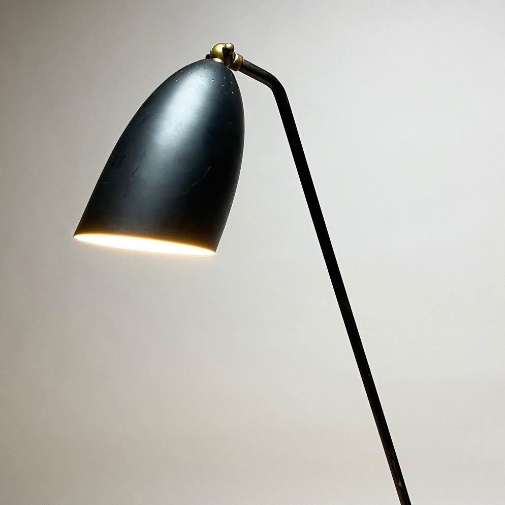 Renowned designer Svend Aage Holm Sørensen designed this iconic floor lamp back in 1950s. 

This particular floor lamp has not been touched besides cleaned with a dry cloth. 

It has a stunning patina with mat black lacquer and two front toe