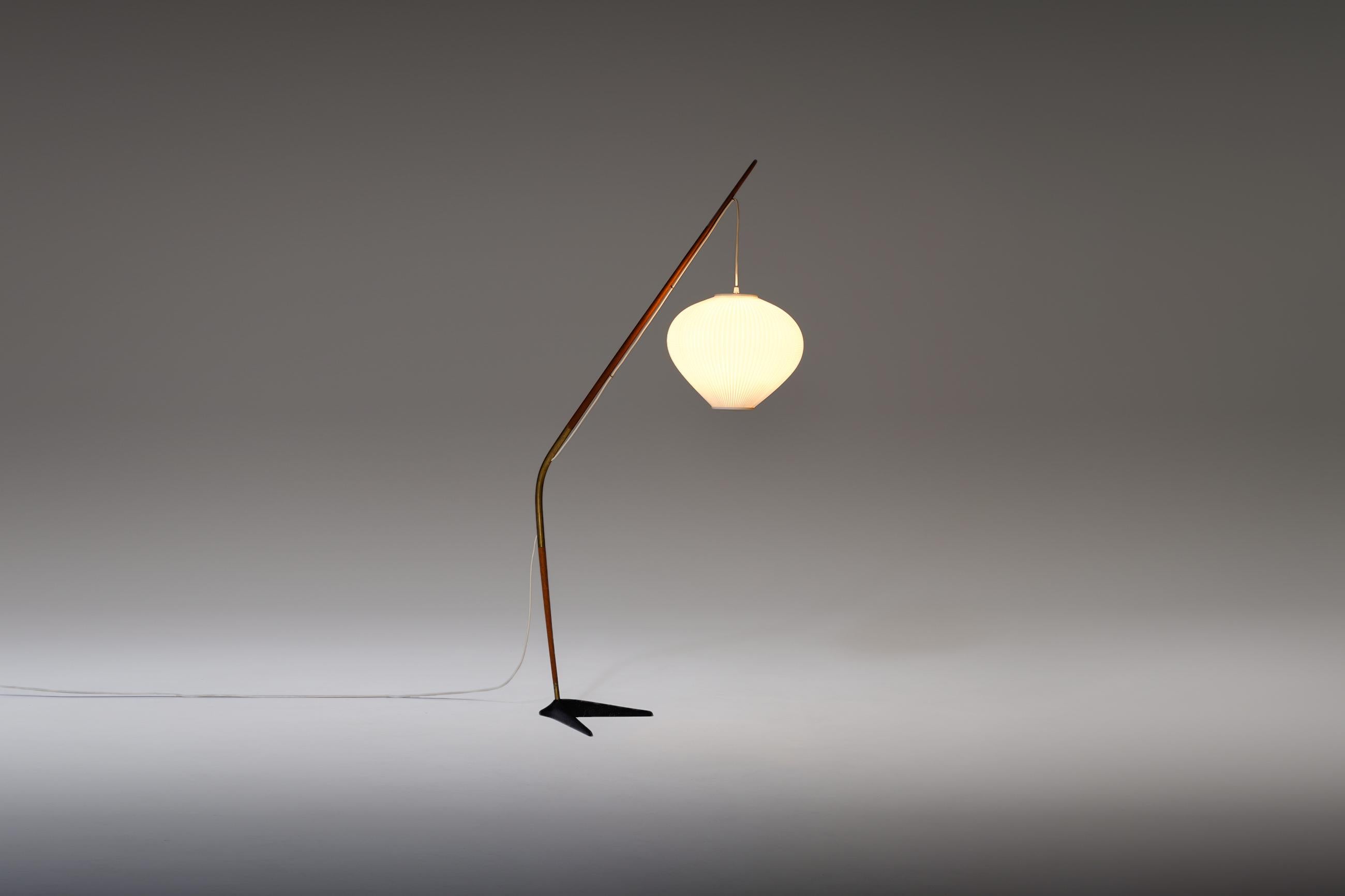 Rare “Fishing Pole” floor lamp by Svend Aage Holm Sorensen, Denmark, 1950s. A well-crafted and elegant midcentury piece composed of teak stem finished with brass details. The black iron base balances the stem and creates a nice contrast between the